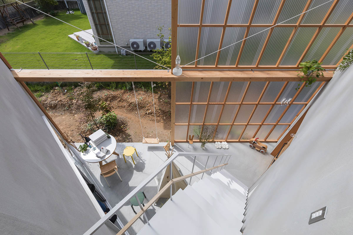 Huge corrugated polycarbonate wall lightens a cornered sunroom in house by Tato Architects