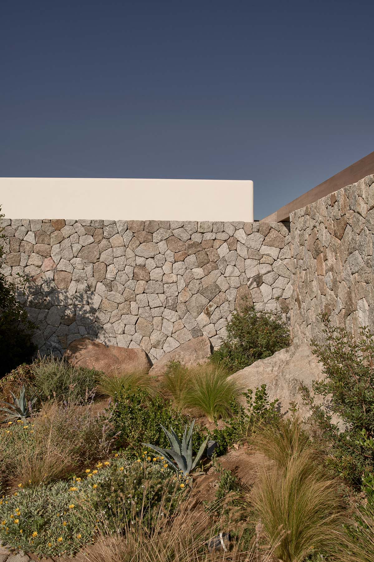 K Studio built small holiday villa with round-edged volumes and shading elements in Mykonos