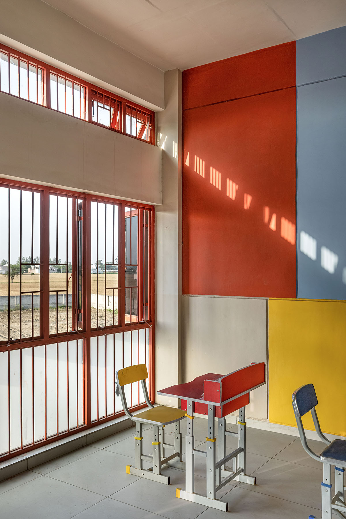 Kamat & Rozario Architecture built school with fortress-like blank walls and colored bridges