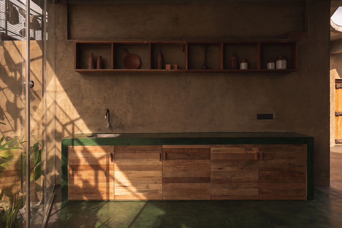 Farm house by Earthscape Studio is wrapped by gabion wall to filter light and airflow in India 