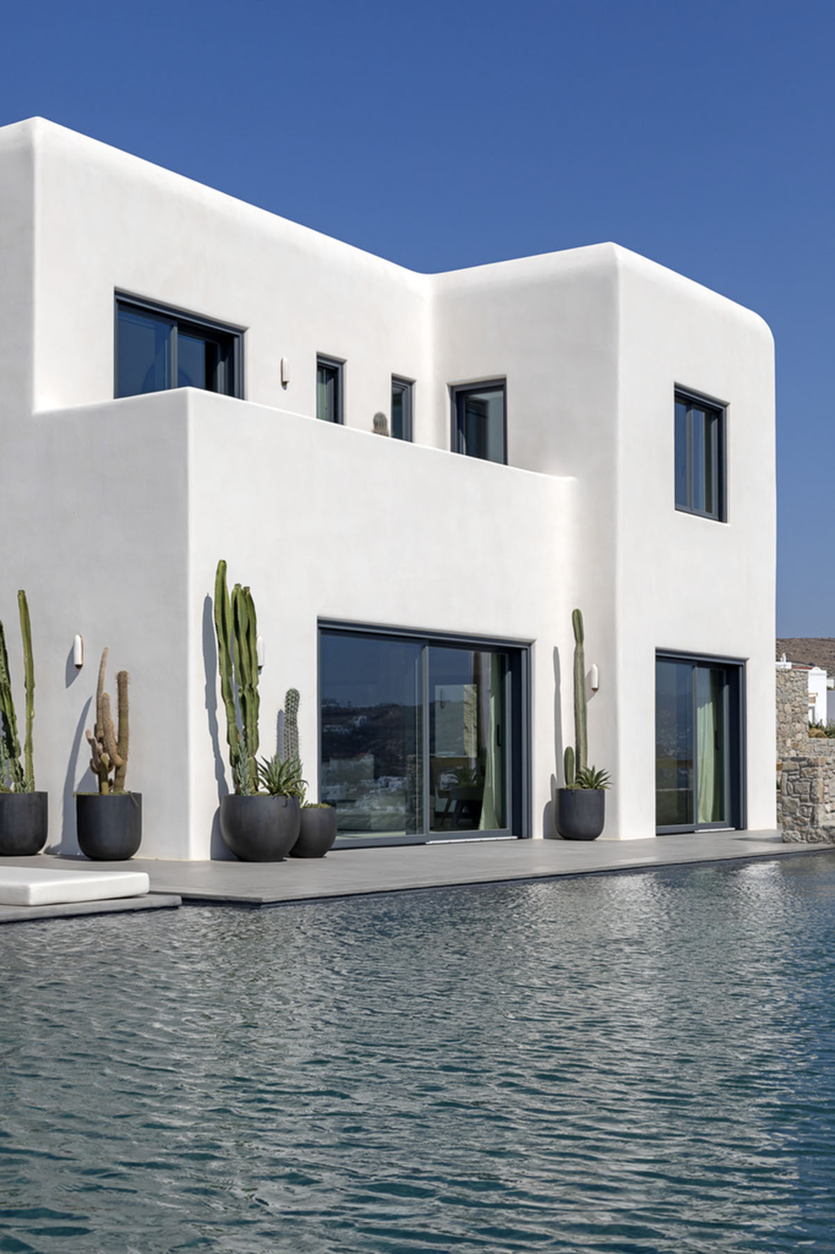 MK Design Studio designs luxurious holiday villa with creamy white walls  and stone-walled terraces