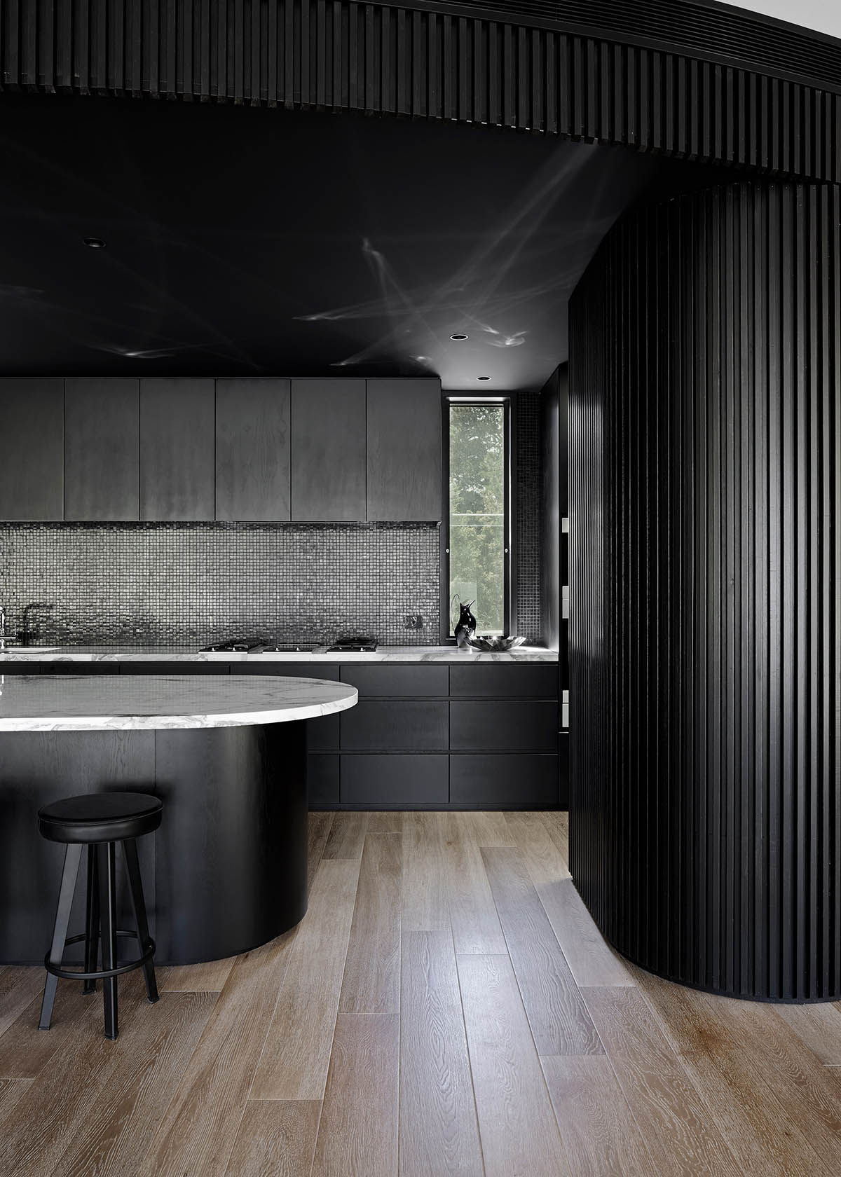 Wood Marsh built curvaceous home clad in dark timber contrasting its natural landscape in Portsea