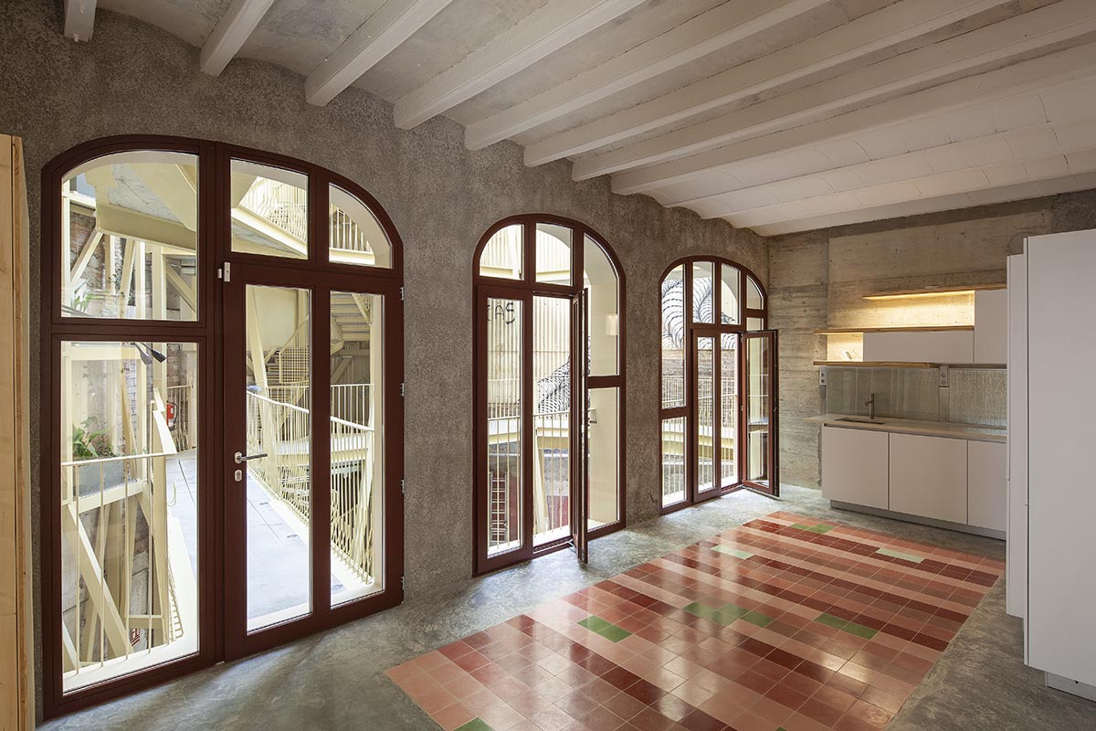 La Carboneria housing block features a dramatic courtyard with crossing beams in Barcelona