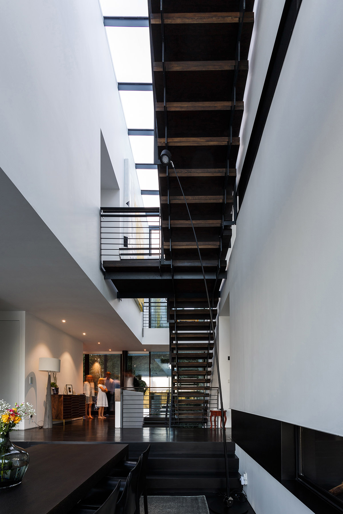 Mecanoo completes glass villa with dark stripes on a lake in Lechlade