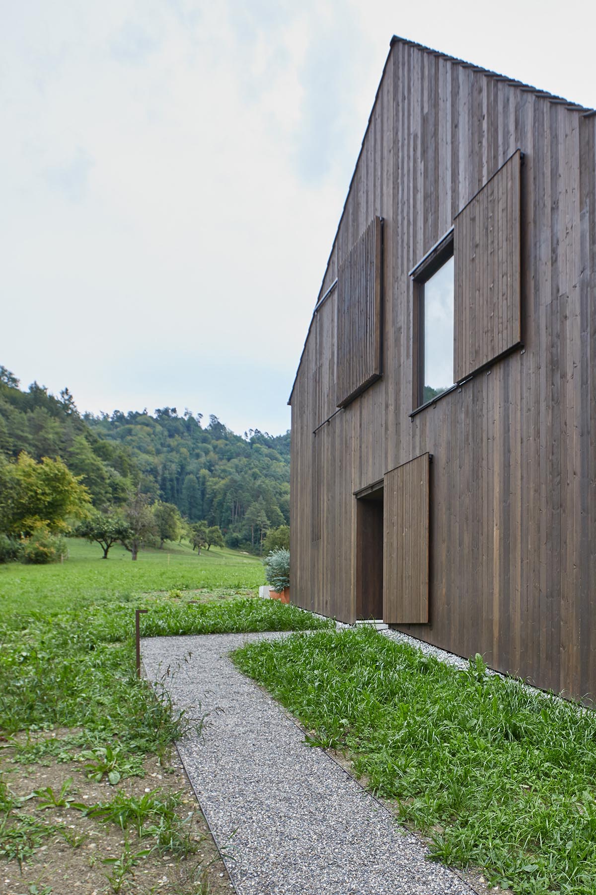 Residential barn features an unfinished, raw interior in Swiss rural landscape