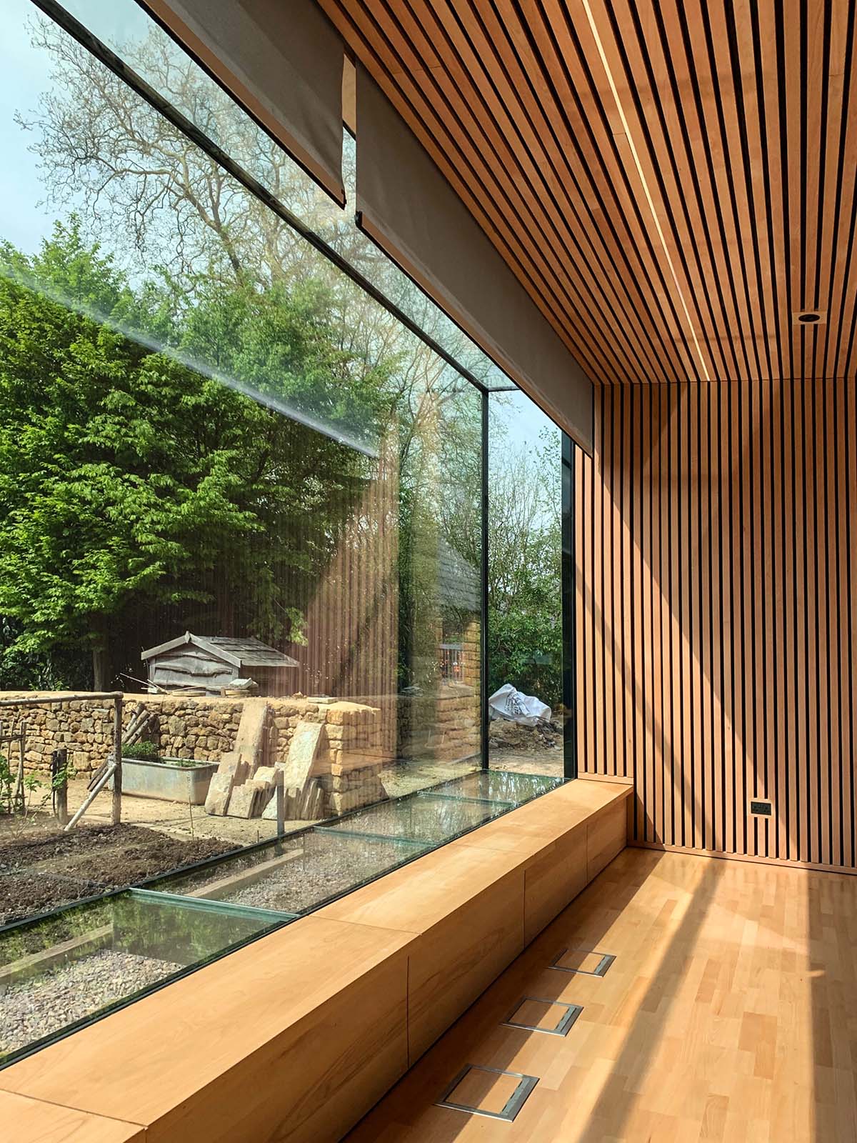 Invisible Studio creates large window for a gymnasium overlooking to a productive garden in Somerset