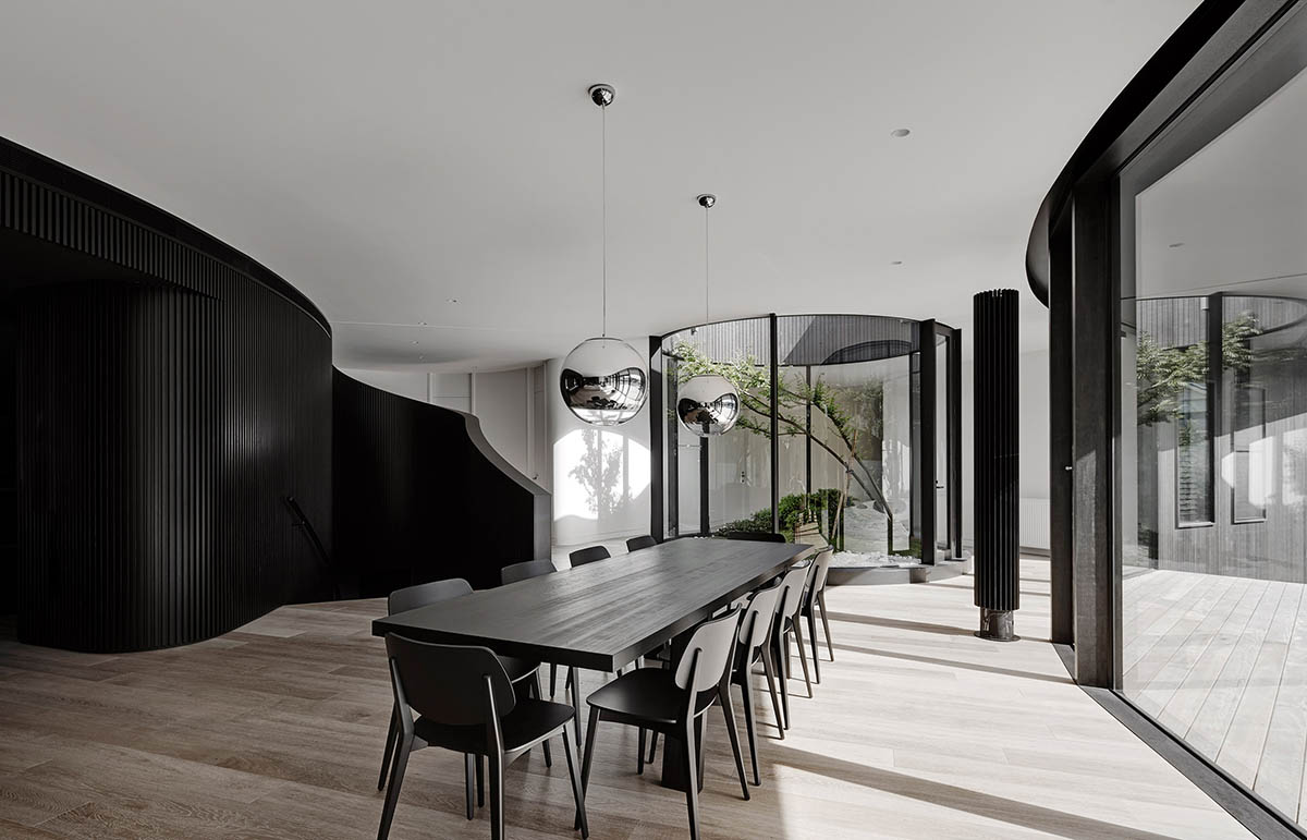 Wood Marsh built curvaceous home clad in dark timber contrasting its natural landscape in Portsea