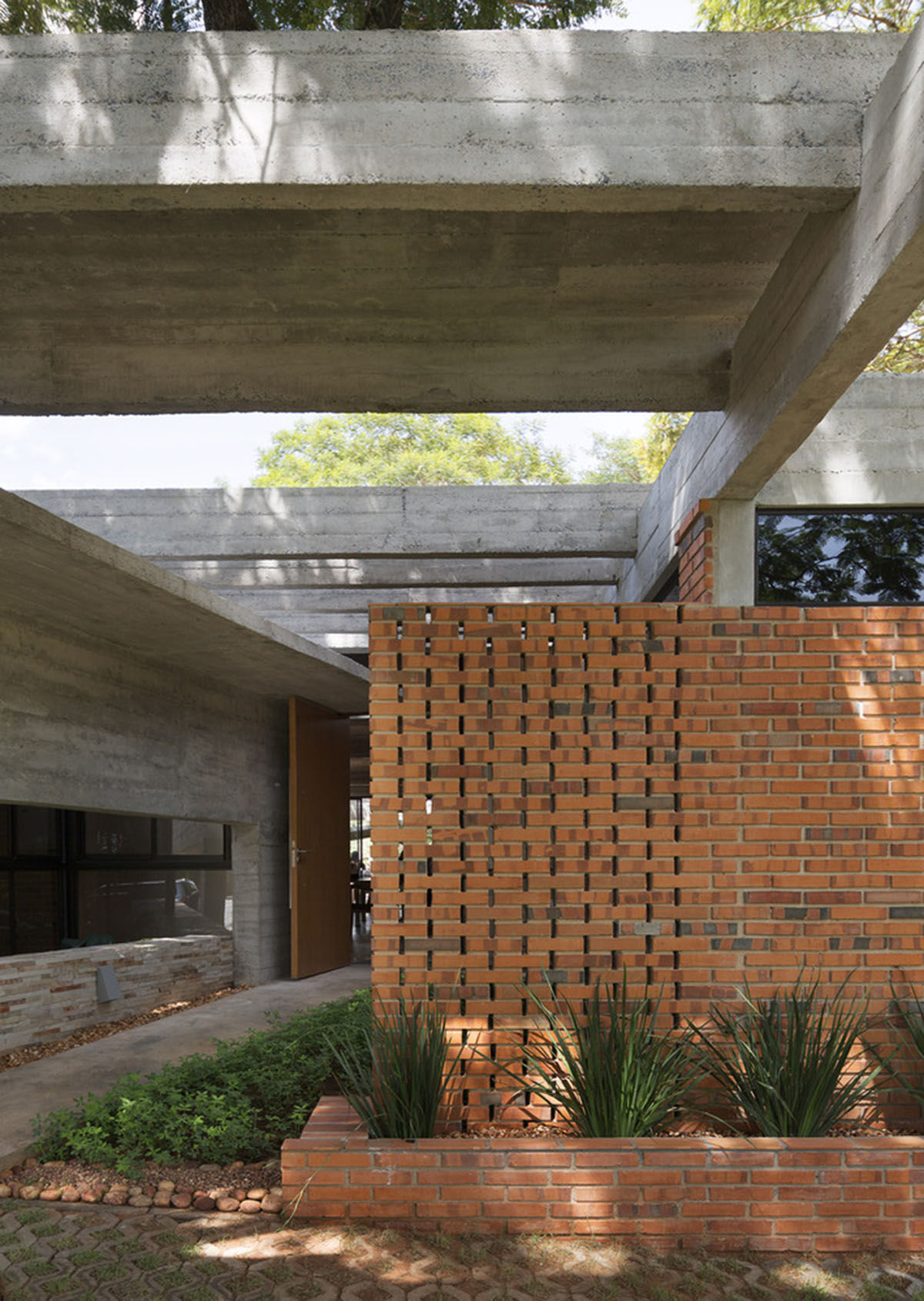 Concrete roof slabs and surfaces freely fly over this brick house in Paraguay by Culata Jovái Group