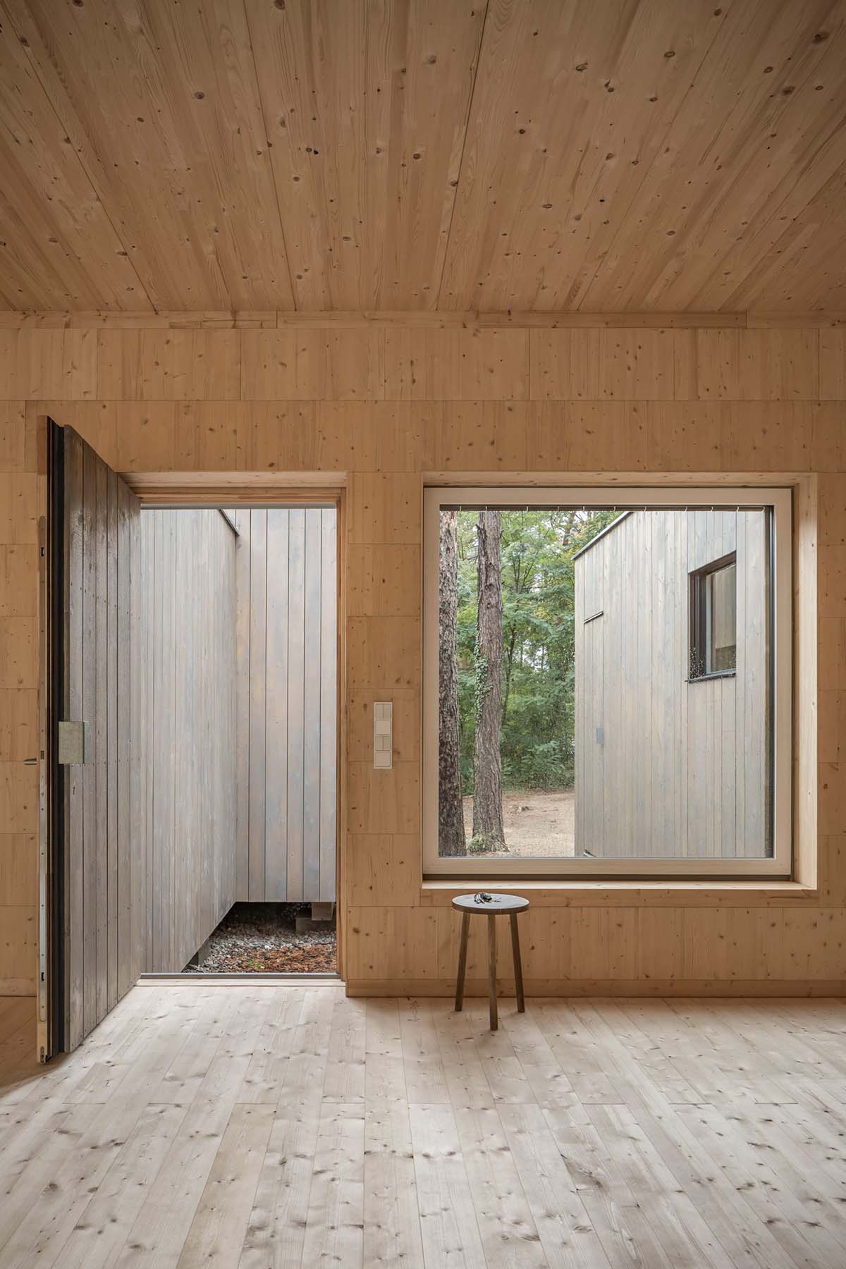 Zeller & Moye built private residence composed of interlocked timber cabins among pine trees