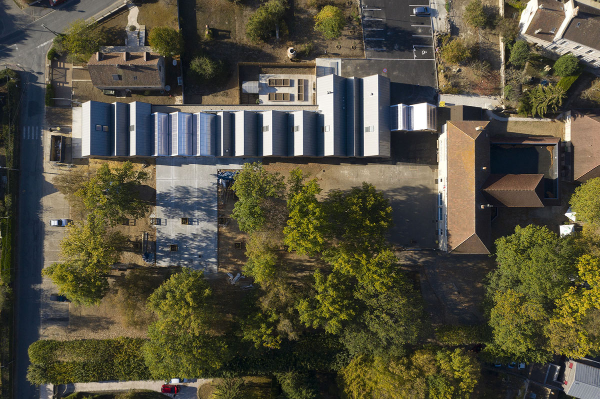 This human-scale school in French town wrapped by different geometry of wood claddings