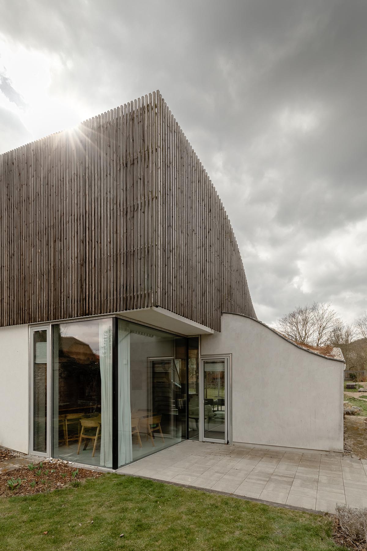 Family house by RO_AR merges two geometries with undulating grass-filled roof in the Czech Republic