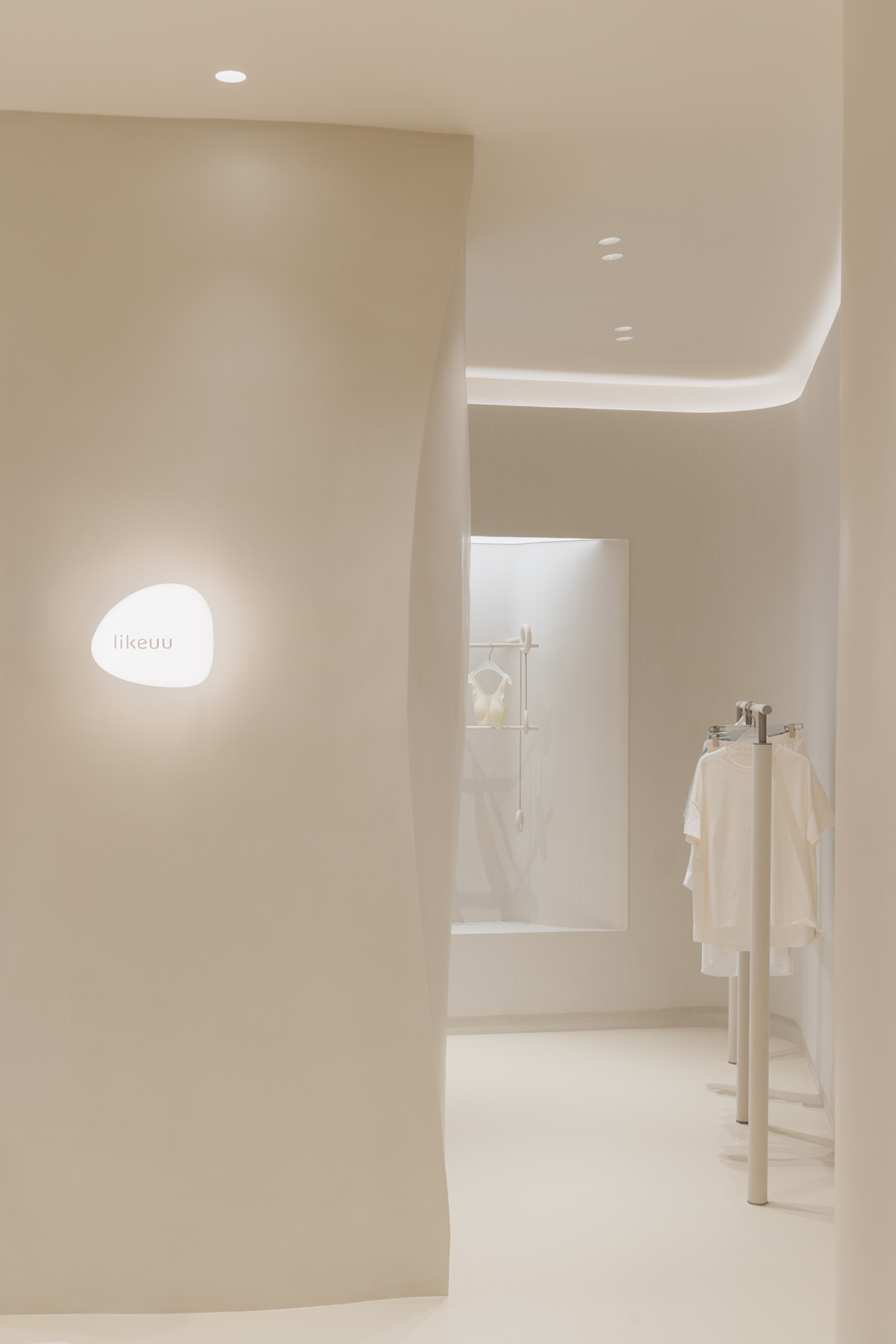 Store interiors by Sò Studio feature soft beige tones to give the feeling of