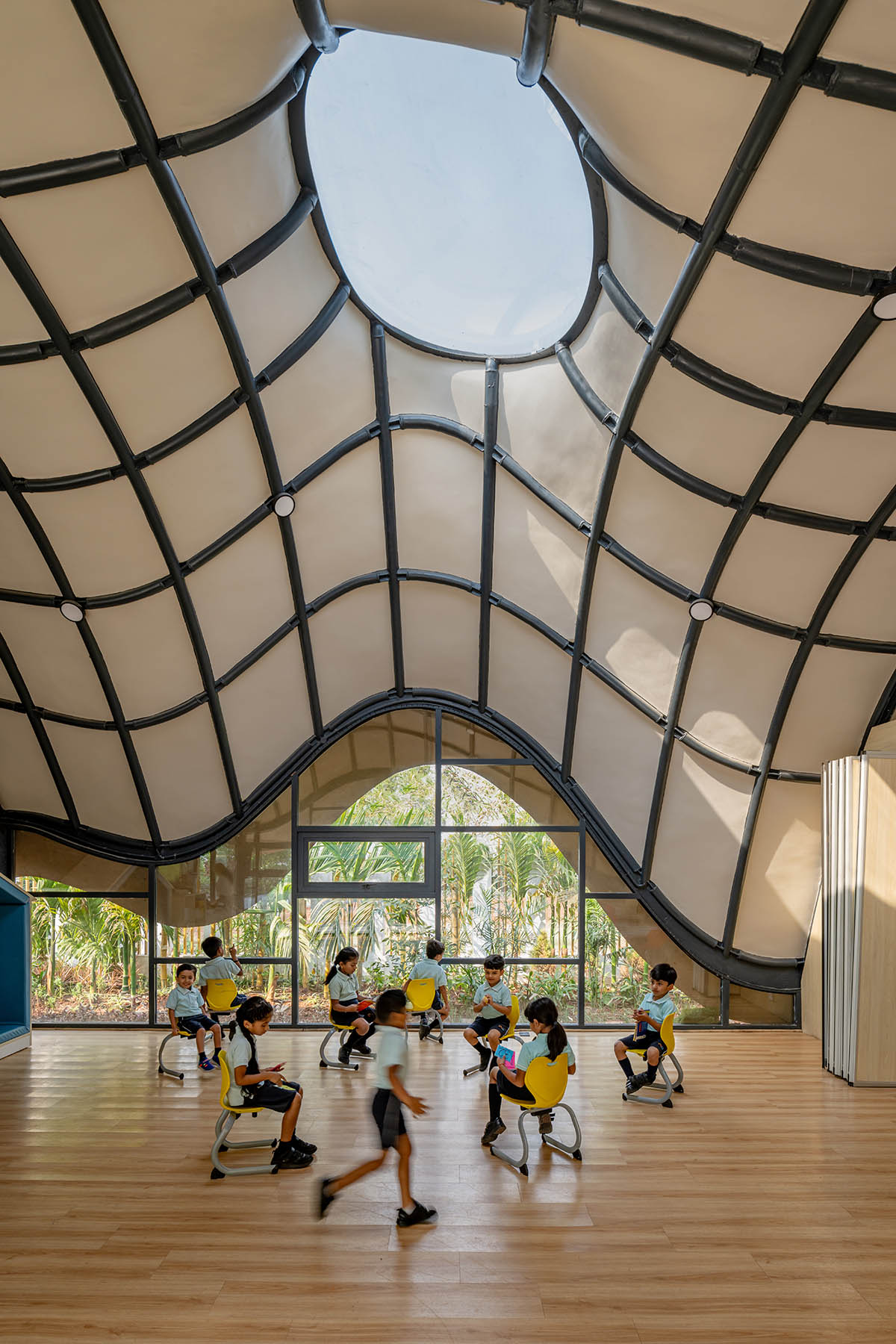 Undulating roof covers Cocoon School for unobstructed space in India 