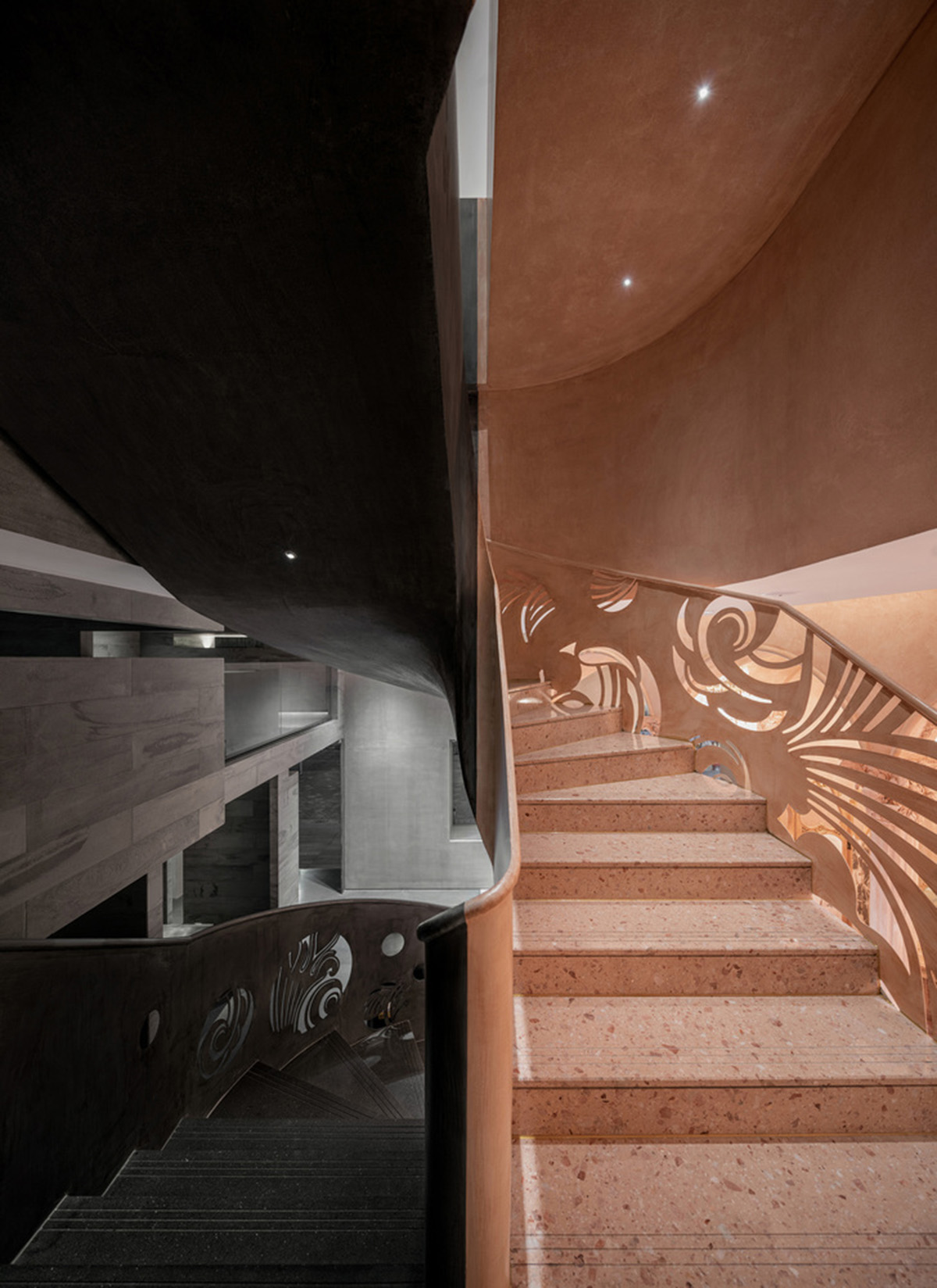 Pink elements and dark colors create sharp contrast in the interiors of restaurant and showroom