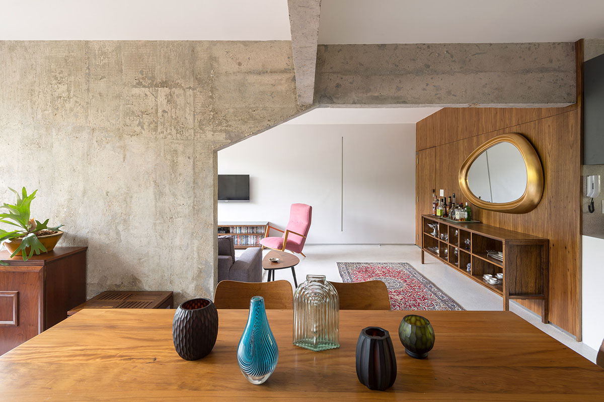 A historic Brazilian apartment has been redesigned with wooden bookcase as main divider