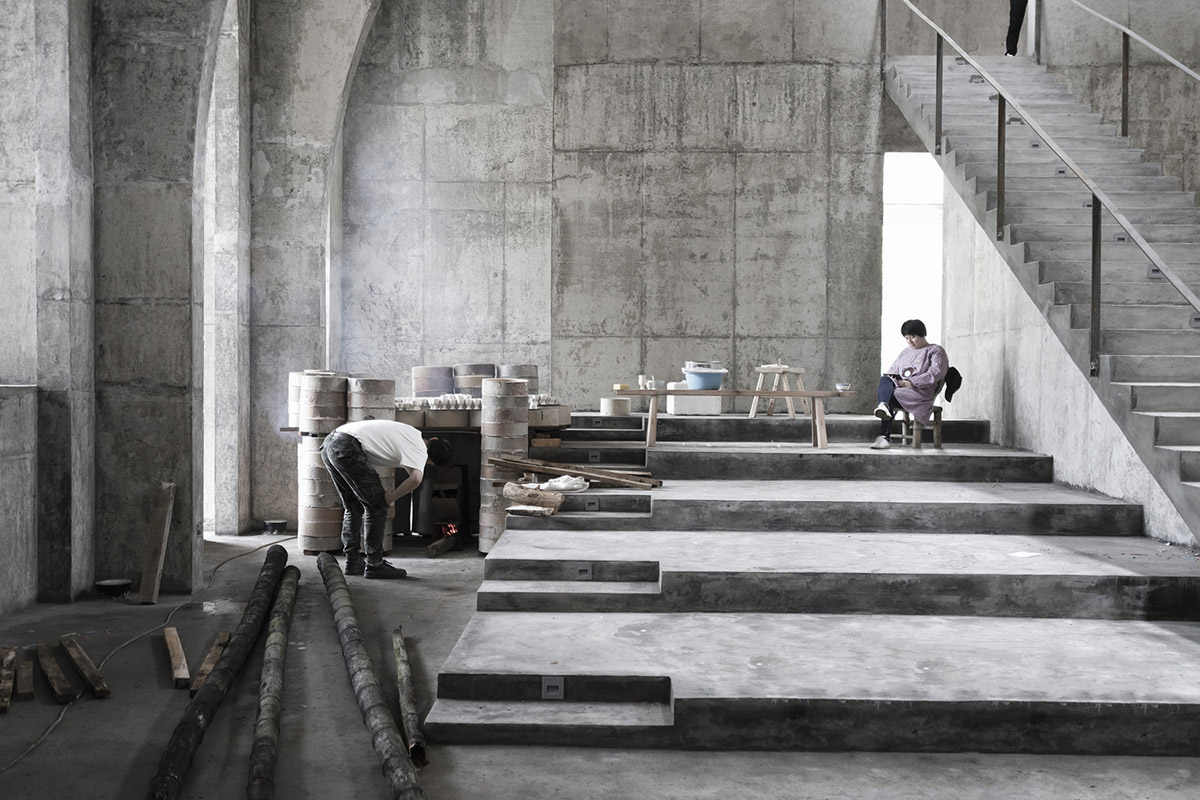 AZL Architects renovates old kiln building with concrete and brick arches in the middle of a forest