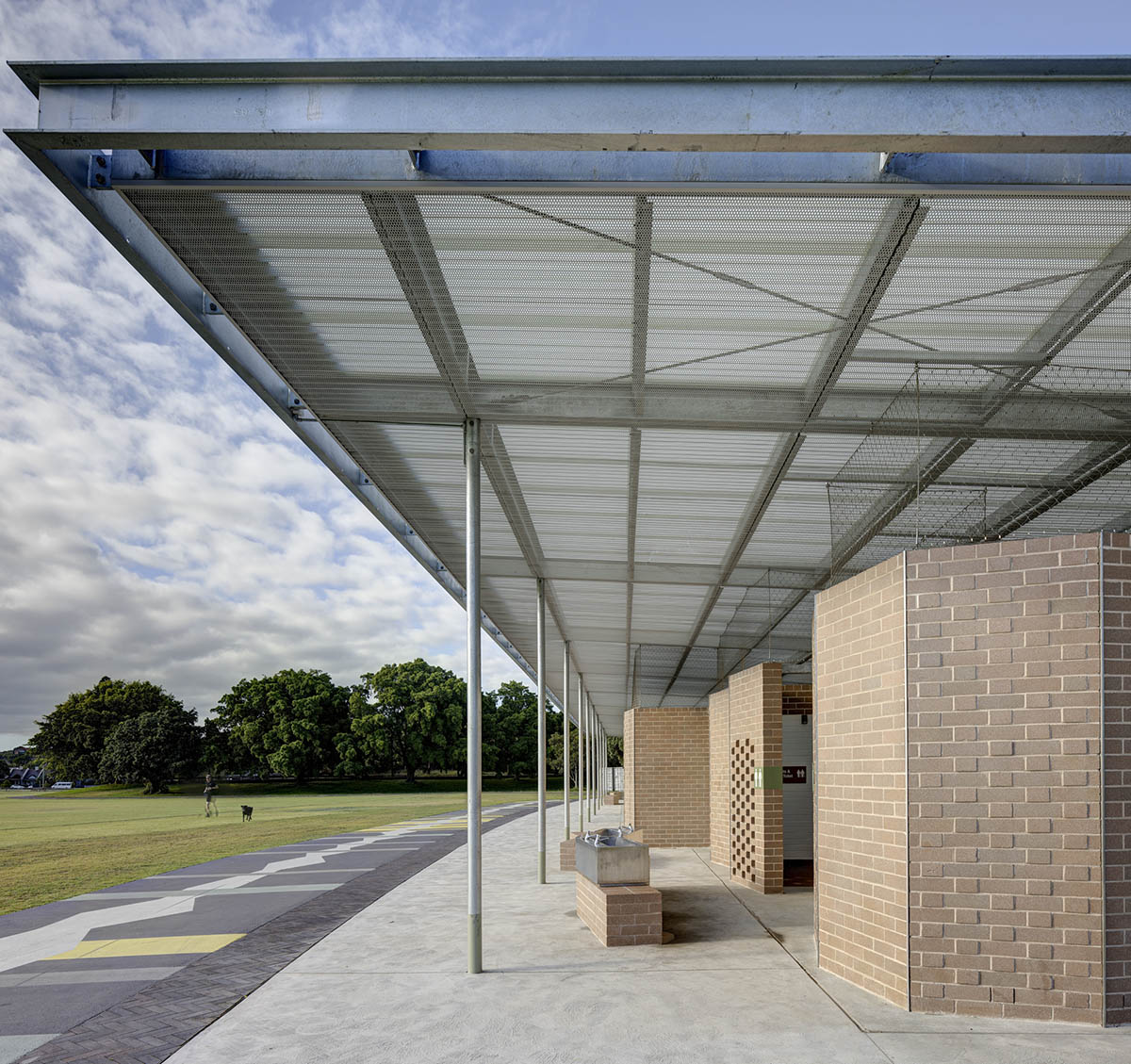 Sports pavilion is made of zigzagging brick walls referencing serrated leaves of endangered banksia