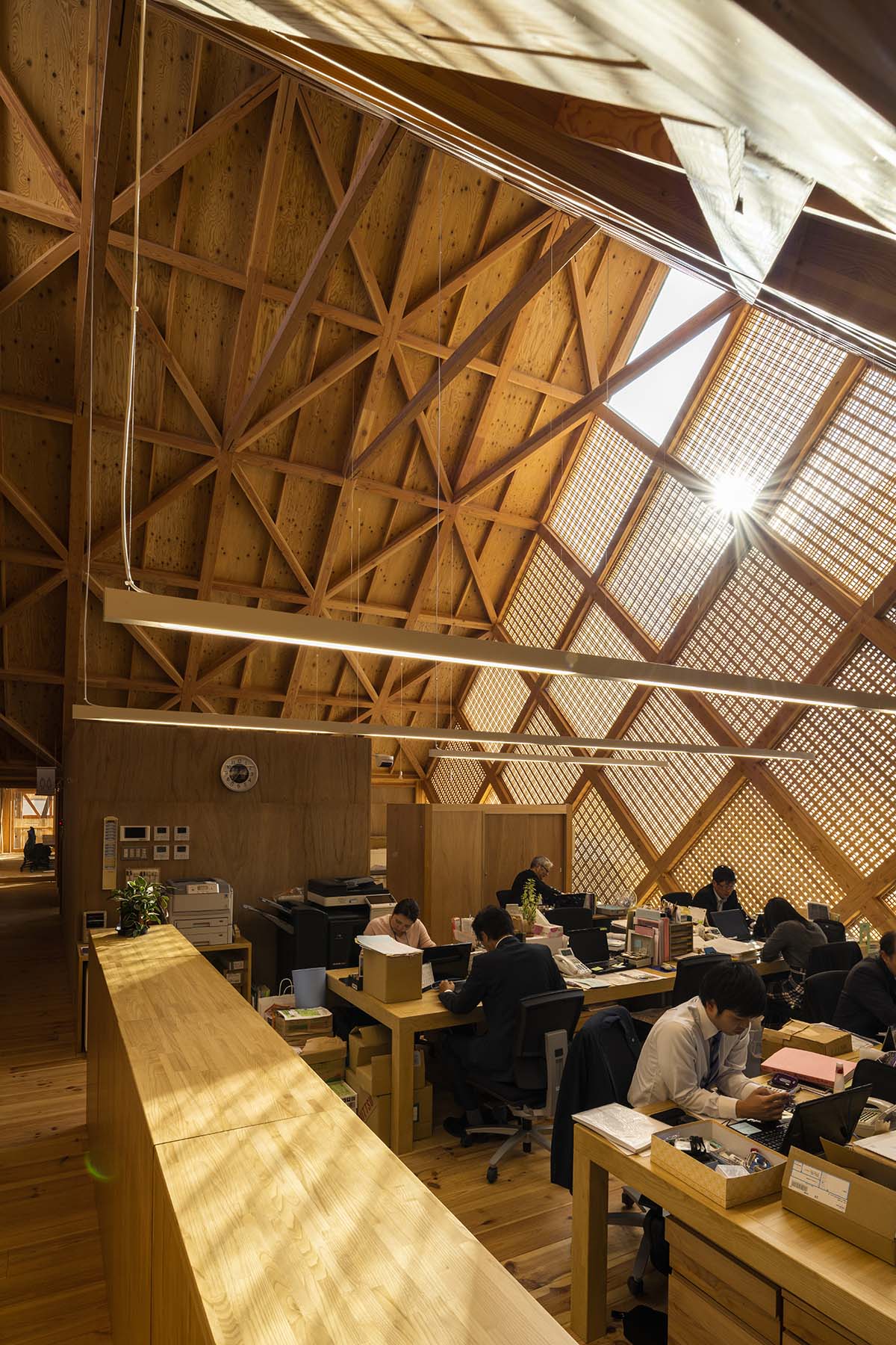 Tezuka Architects' zig zag office building creates lace-like façade with wooden diagonal grids