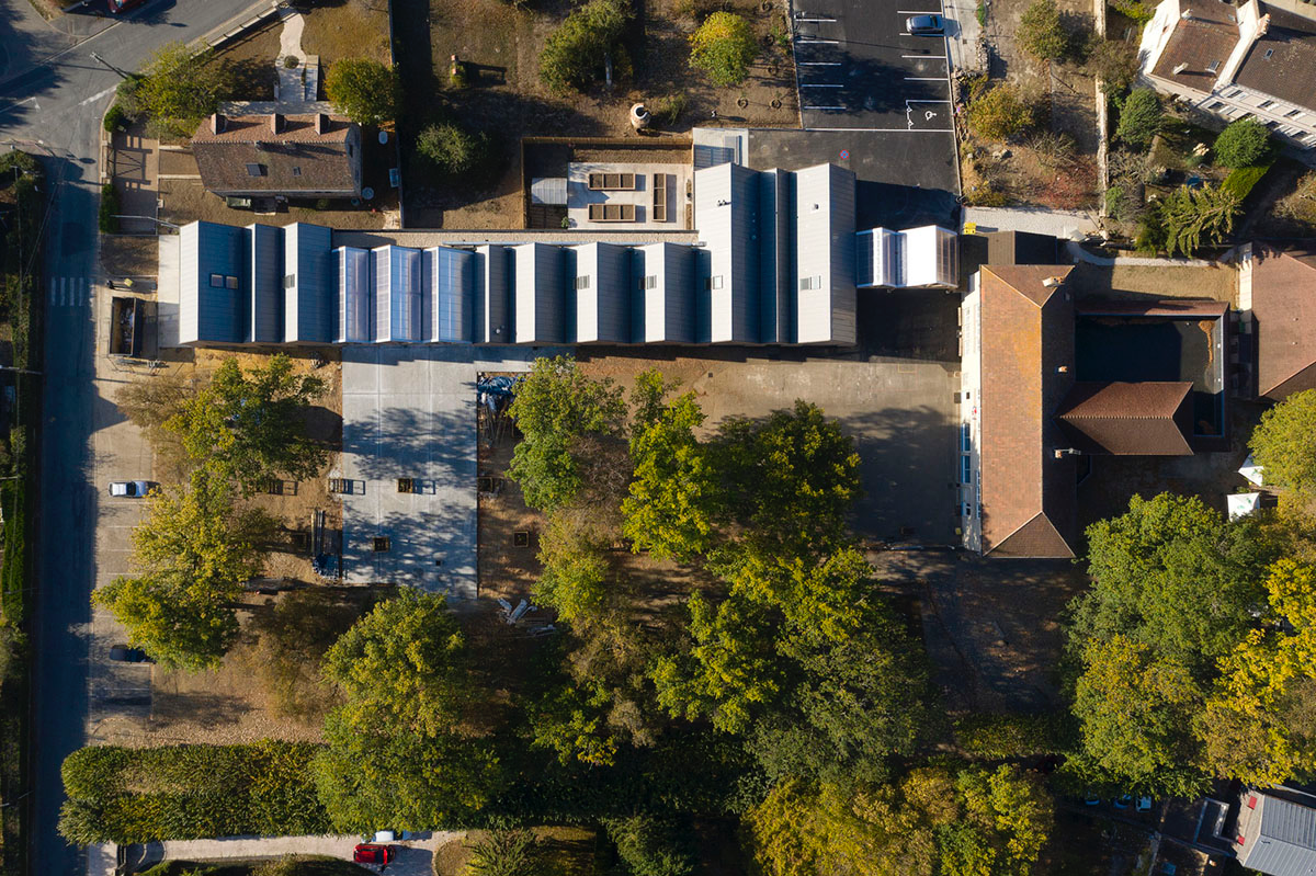 This human-scale school in French town wrapped by different geometry of wood claddings