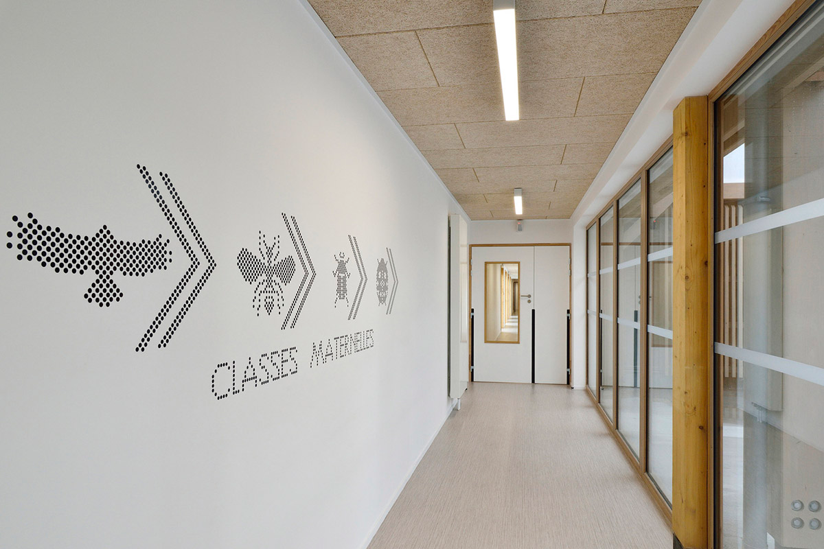 This human-scale school in French town wrapped by different geometry of wood claddings