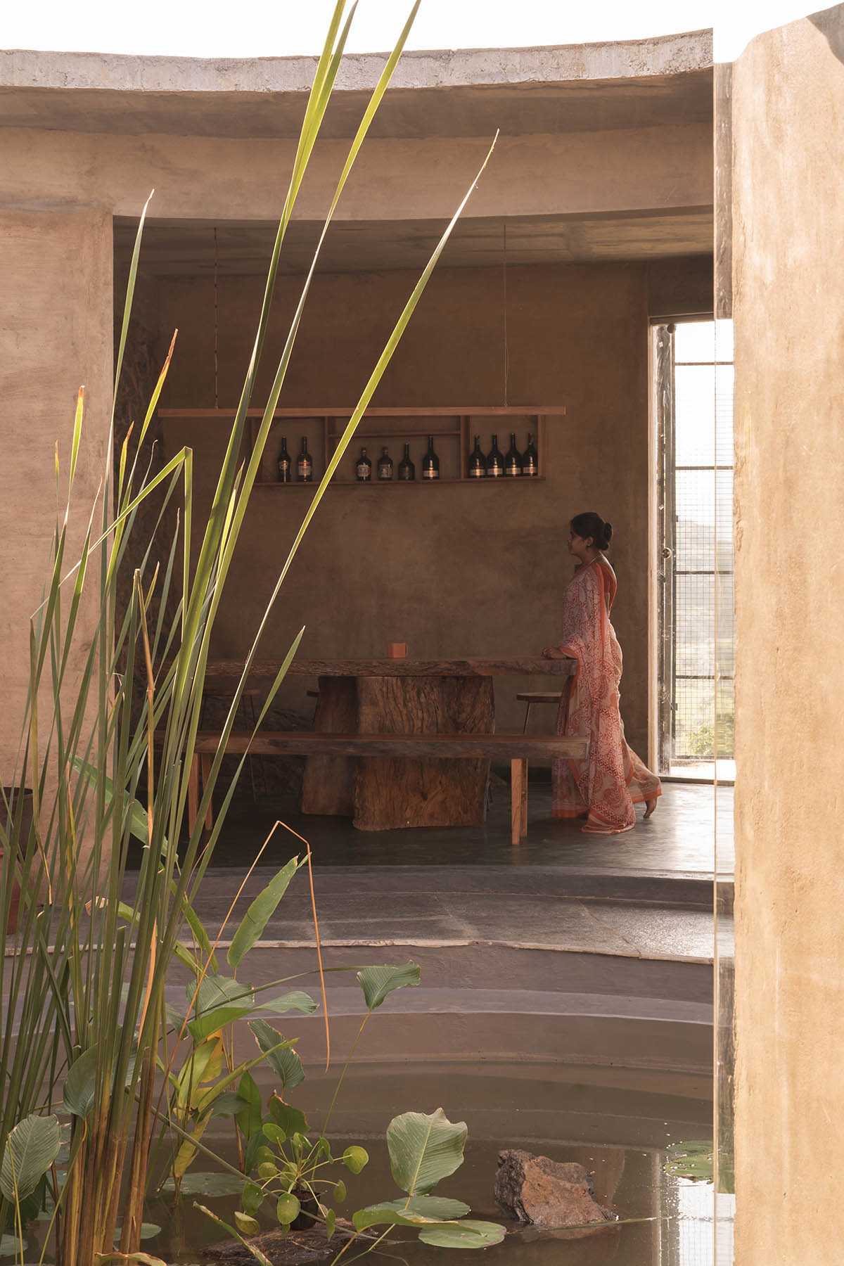 Farm house by Earthscape Studio is wrapped by gabion wall to filter light and airflow in India 