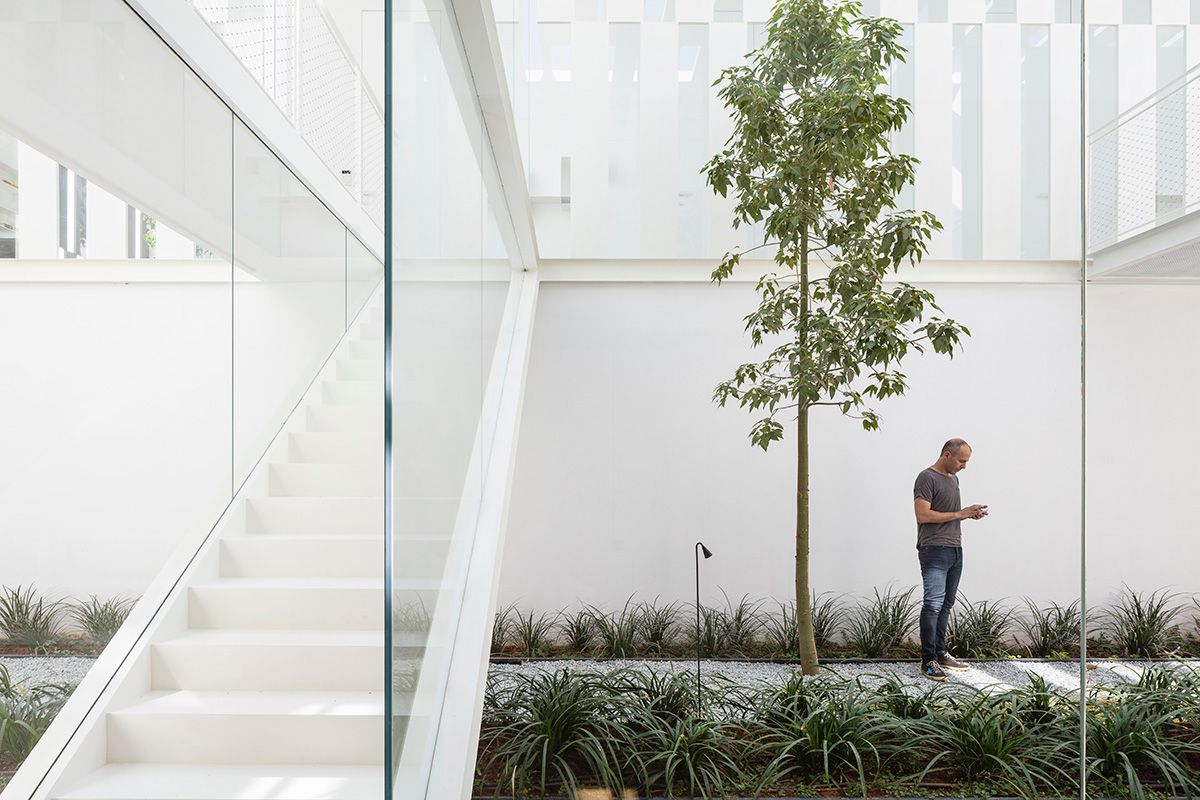 Large sunken yard defines the program of Split House designed by Pitsou Kedem Architects in Israel