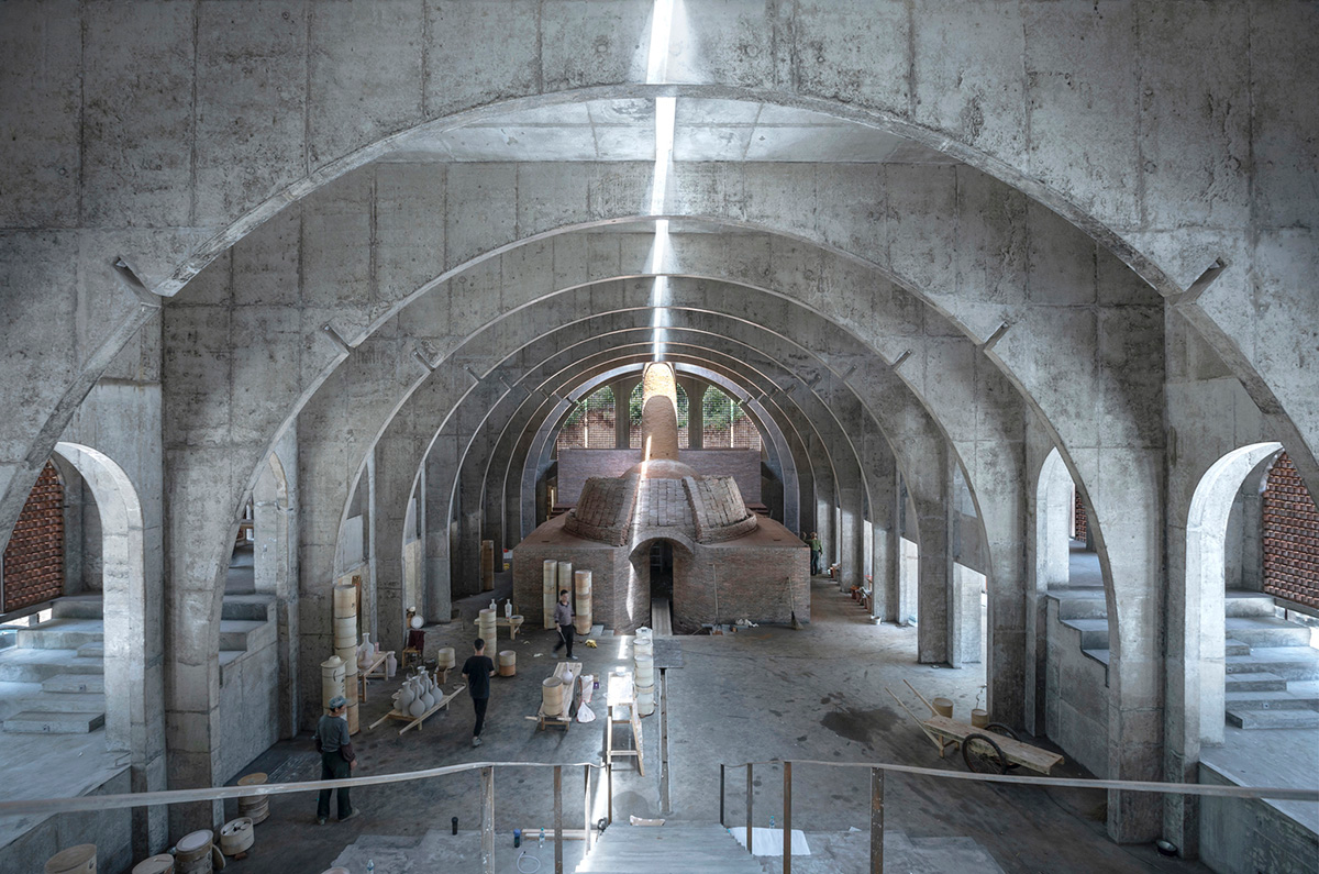 AZL Architects renovates old kiln building with concrete and brick arches in the middle of a forest