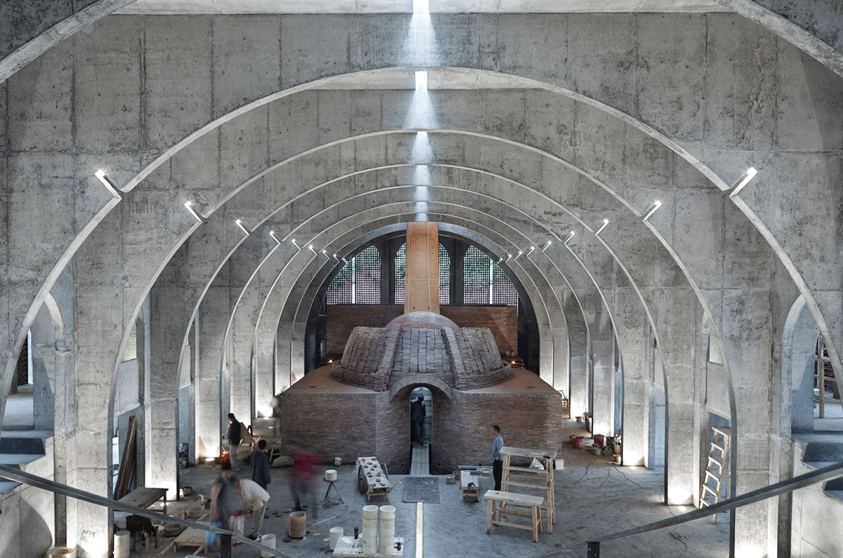 AZL Architects renovates old kiln building with concrete and brick arches in the middle of a forest