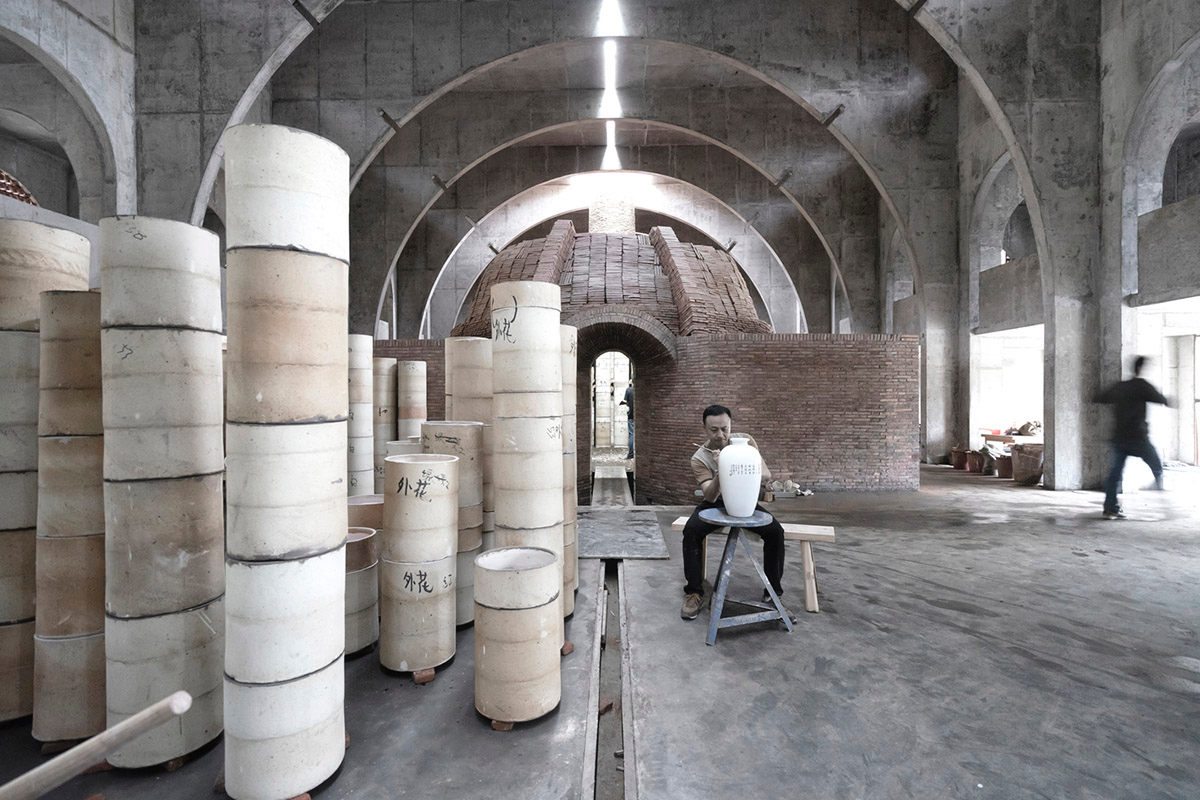 AZL Architects renovates old kiln building with concrete and brick arches in the middle of a forest