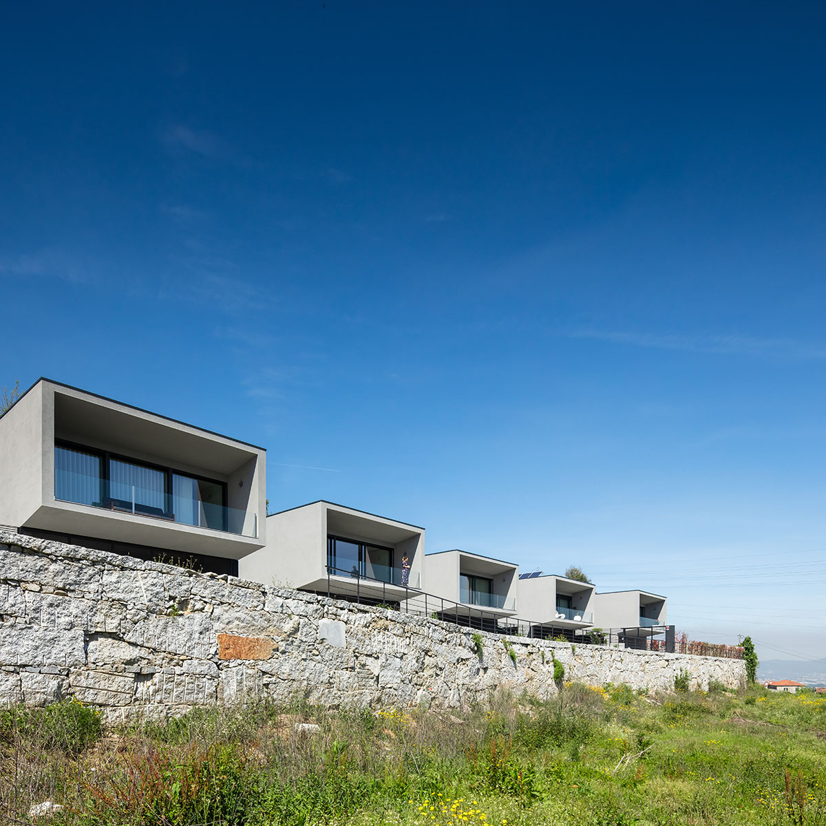 Grupo Zegnea's linear Portuguese houses create fluidity of space with large openings towards nature
