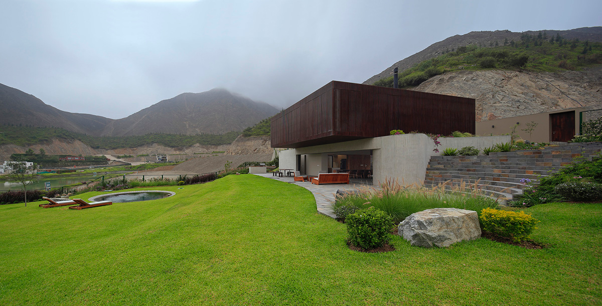 Large semi-buried social space creates a rustic and organic feeling under wooden volume built in Peru