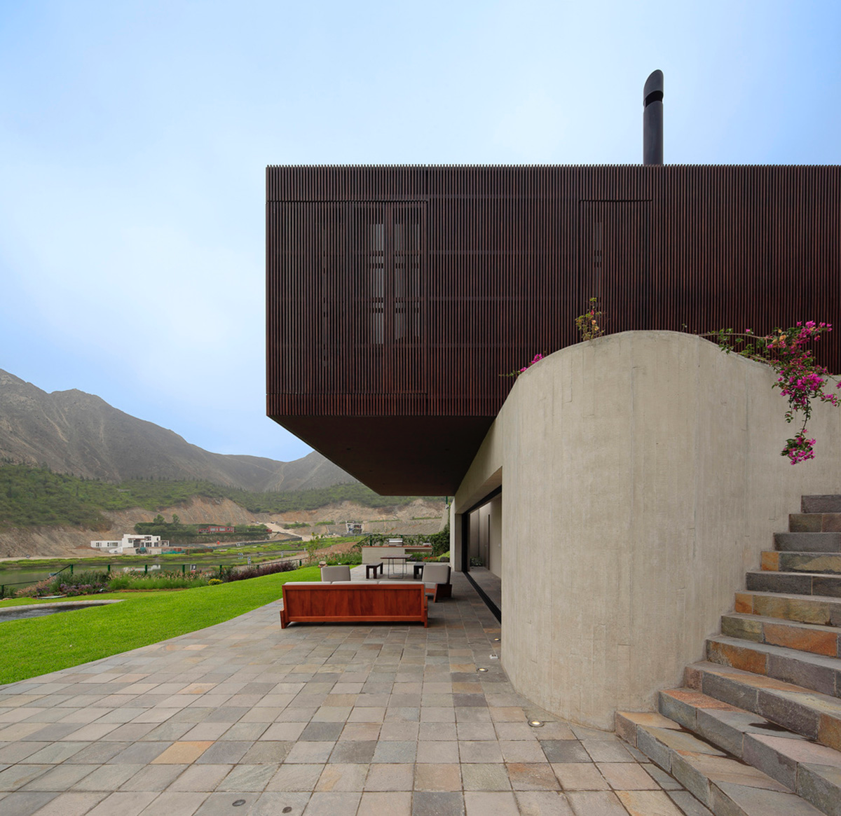 Large semi-buried social space creates a rustic and organic feeling under wooden volume built in Peru
