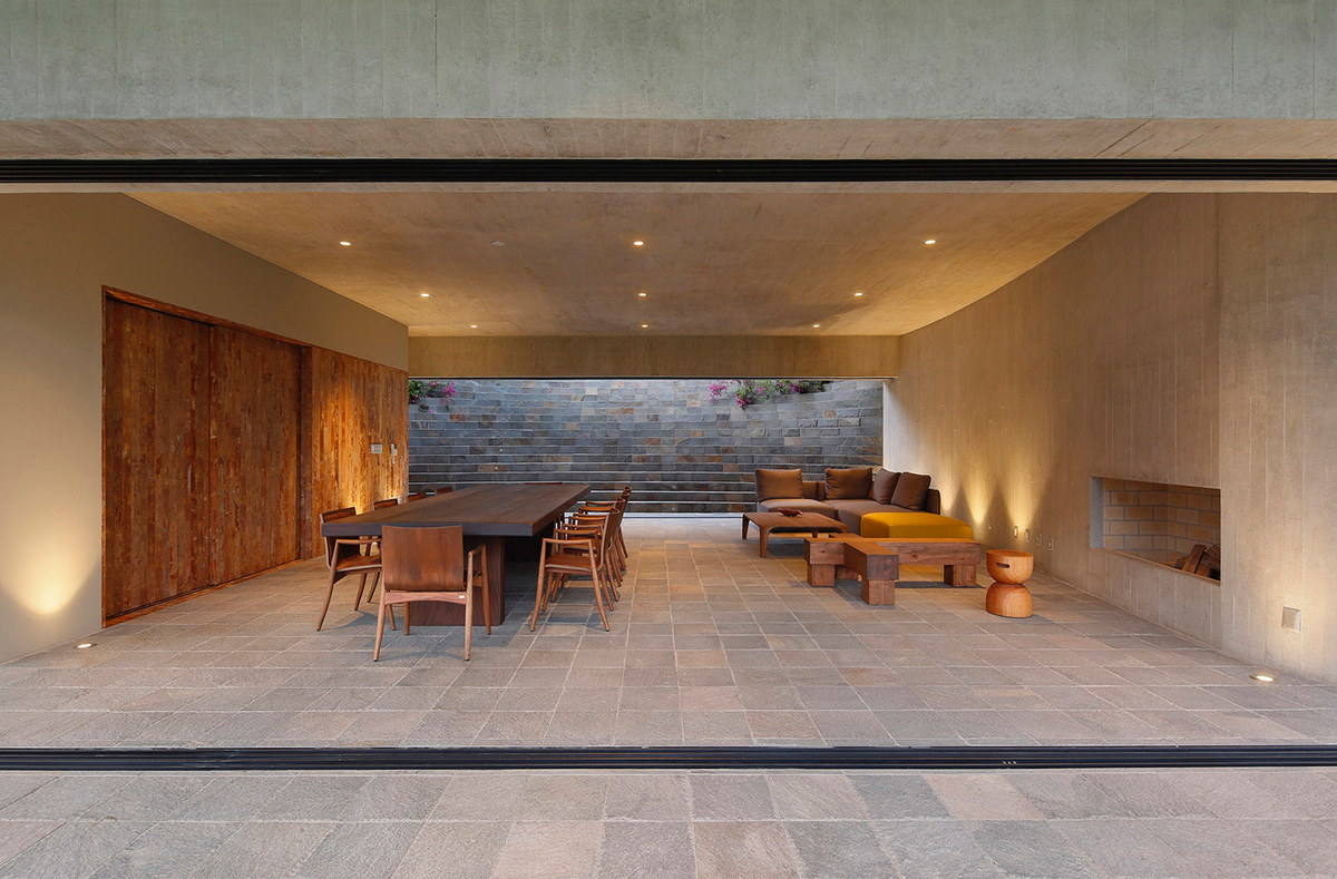 Large semi-buried social space creates a rustic and organic feeling under wooden volume built in Peru