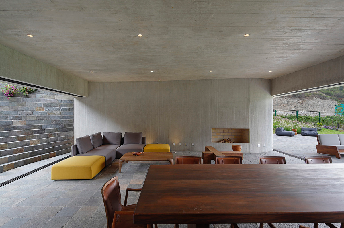 Large semi-buried social space creates a rustic and organic feeling under wooden volume built in Peru