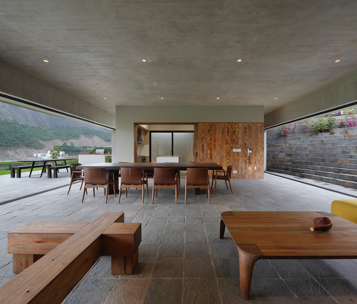 Large semi-buried social space creates a rustic and organic feeling under wooden volume built in Peru
