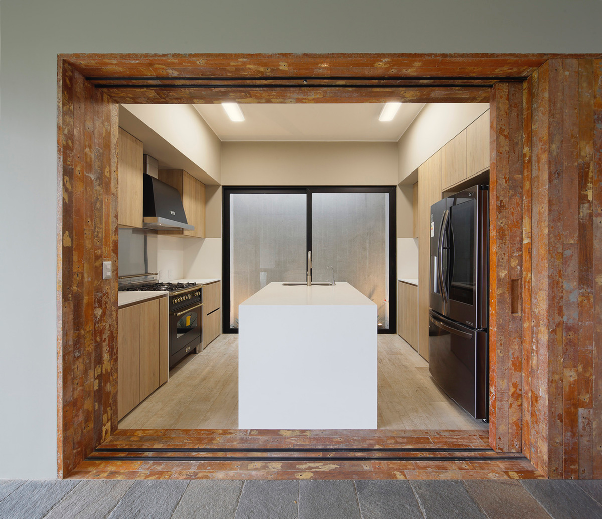 Large semi-buried social space creates a rustic and organic feeling under wooden volume built in Peru