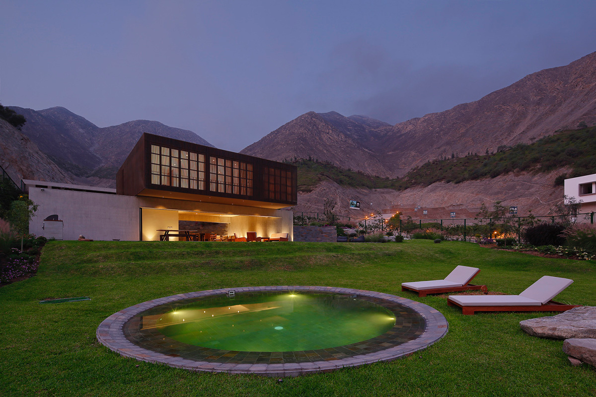 Large semi-buried social space creates a rustic and organic feeling under wooden volume built in Peru
