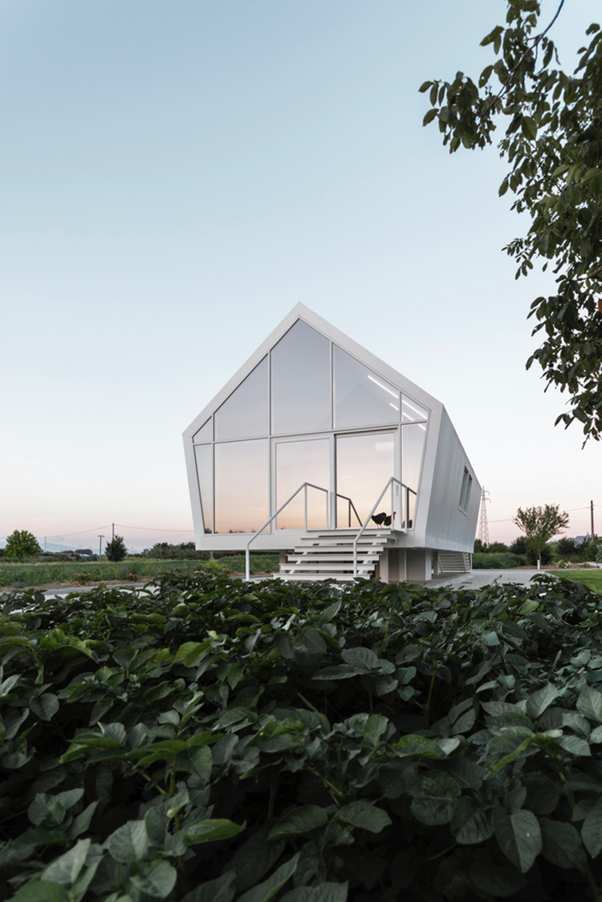LDA.iMdA architetti associati built modular house raised on stilts in the middle of orchard in Italy