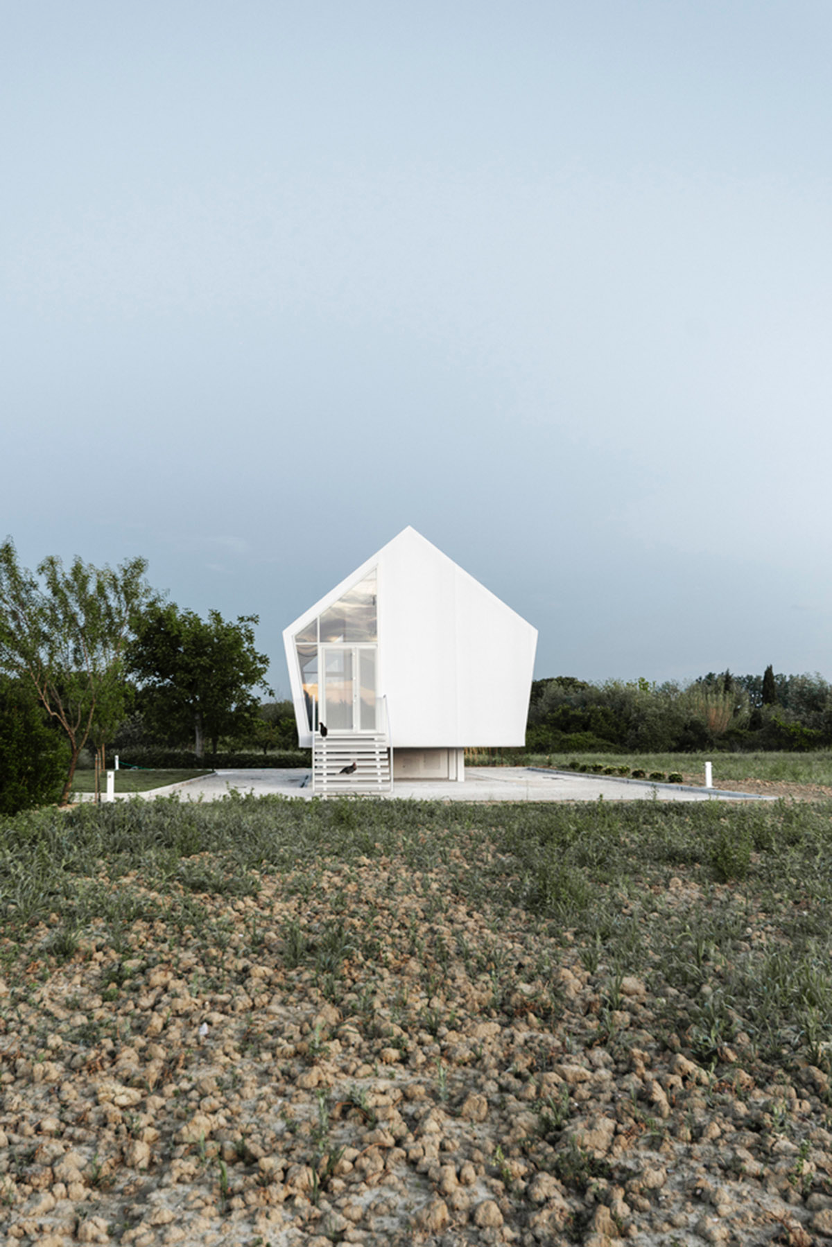 LDA.iMdA architetti associati built modular house raised on stilts in the middle of orchard in Italy