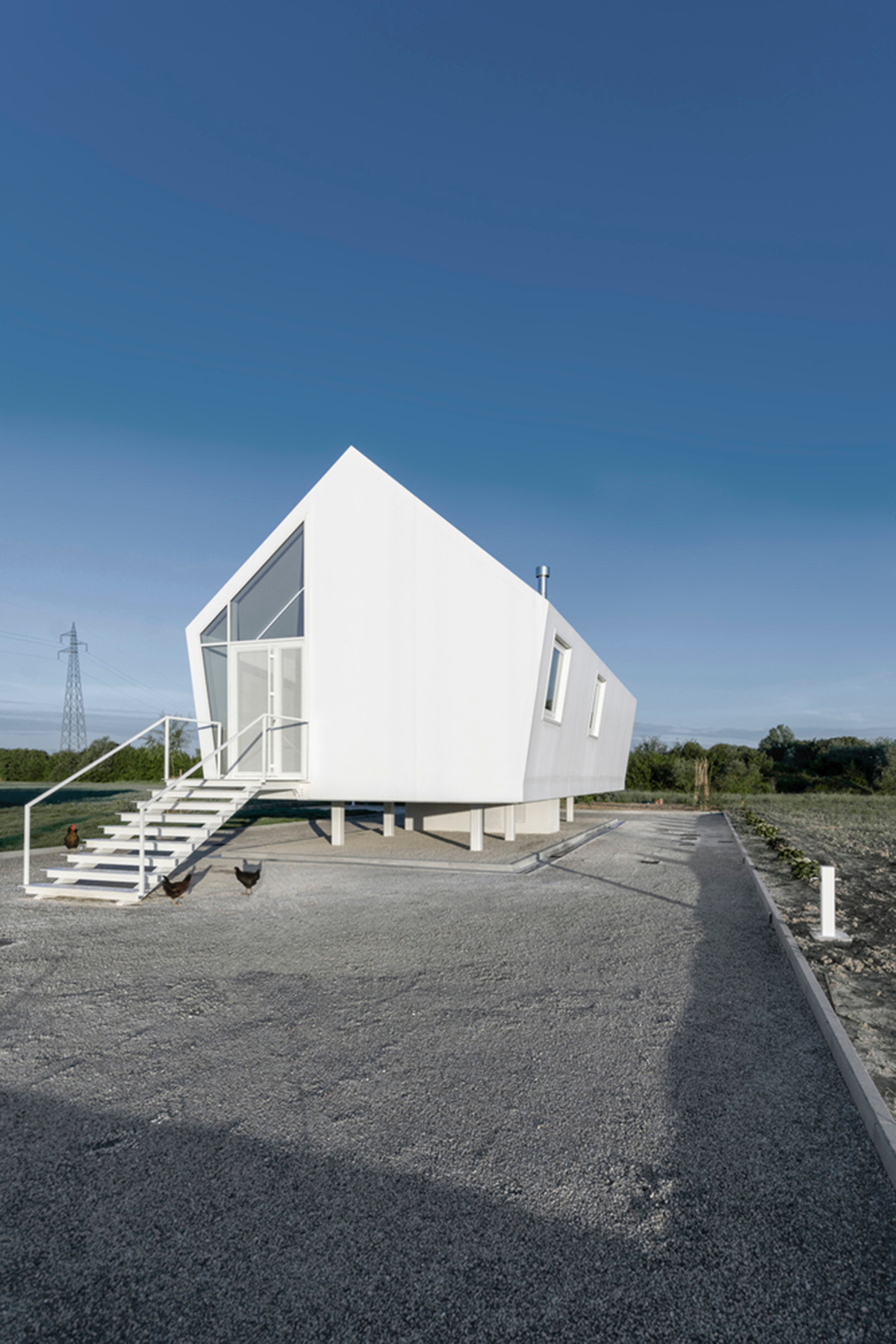 LDA.iMdA architetti associati built modular house raised on stilts in the middle of orchard in Italy