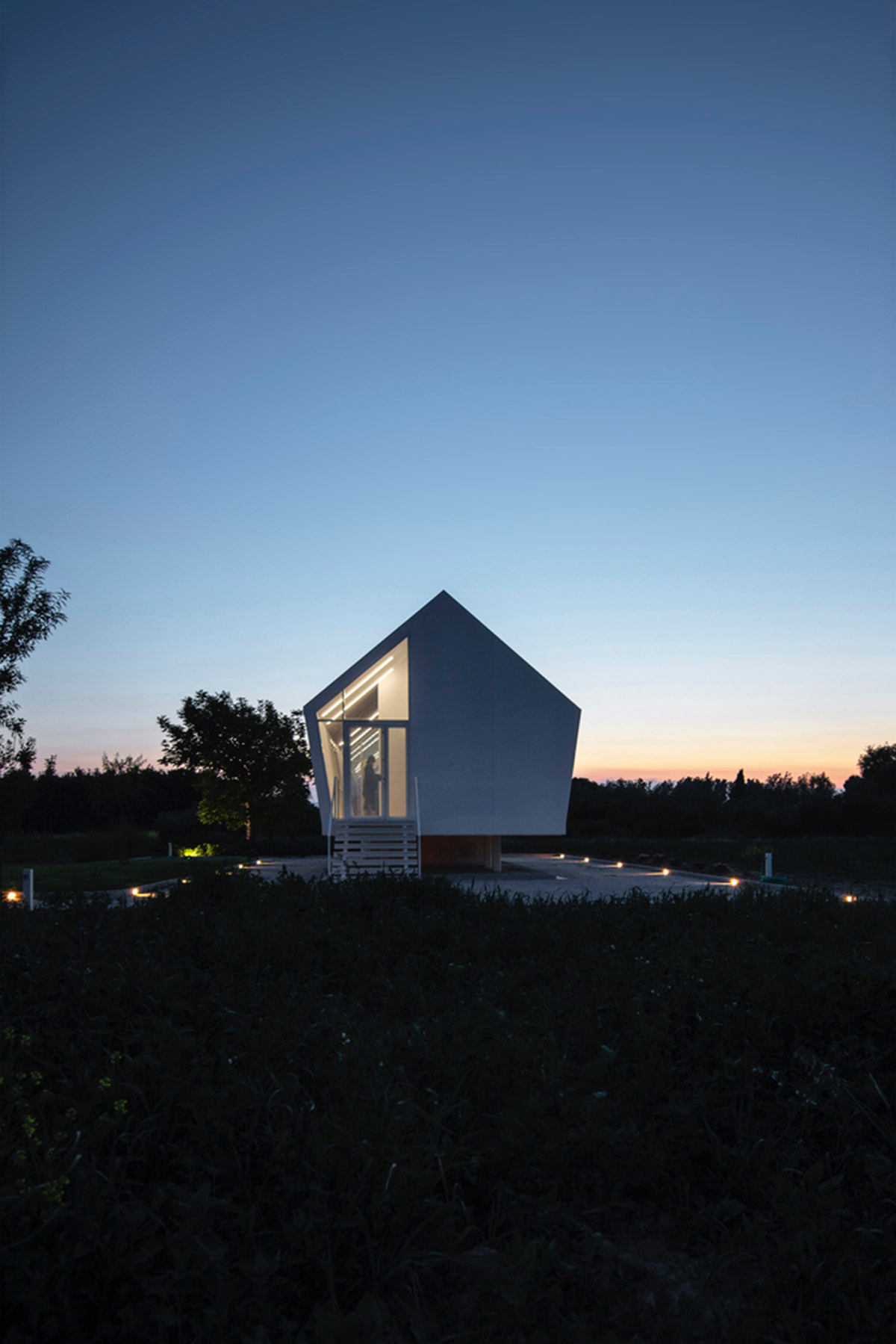 LDA.iMdA architetti associati built modular house raised on stilts in the middle of orchard in Italy