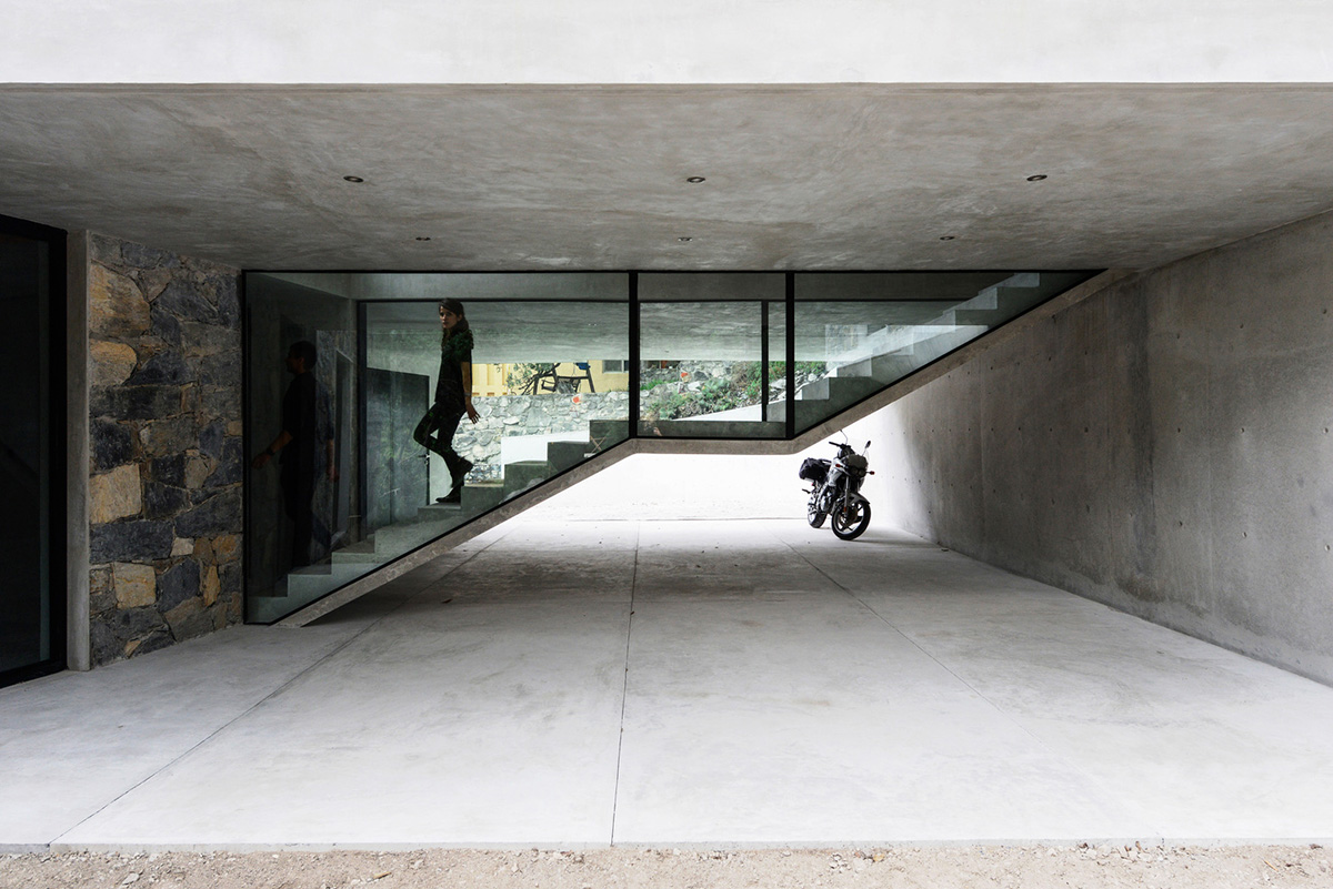 P+0 Arquitectura designs residence mixed with concrete and stone volumes on a complex terrain