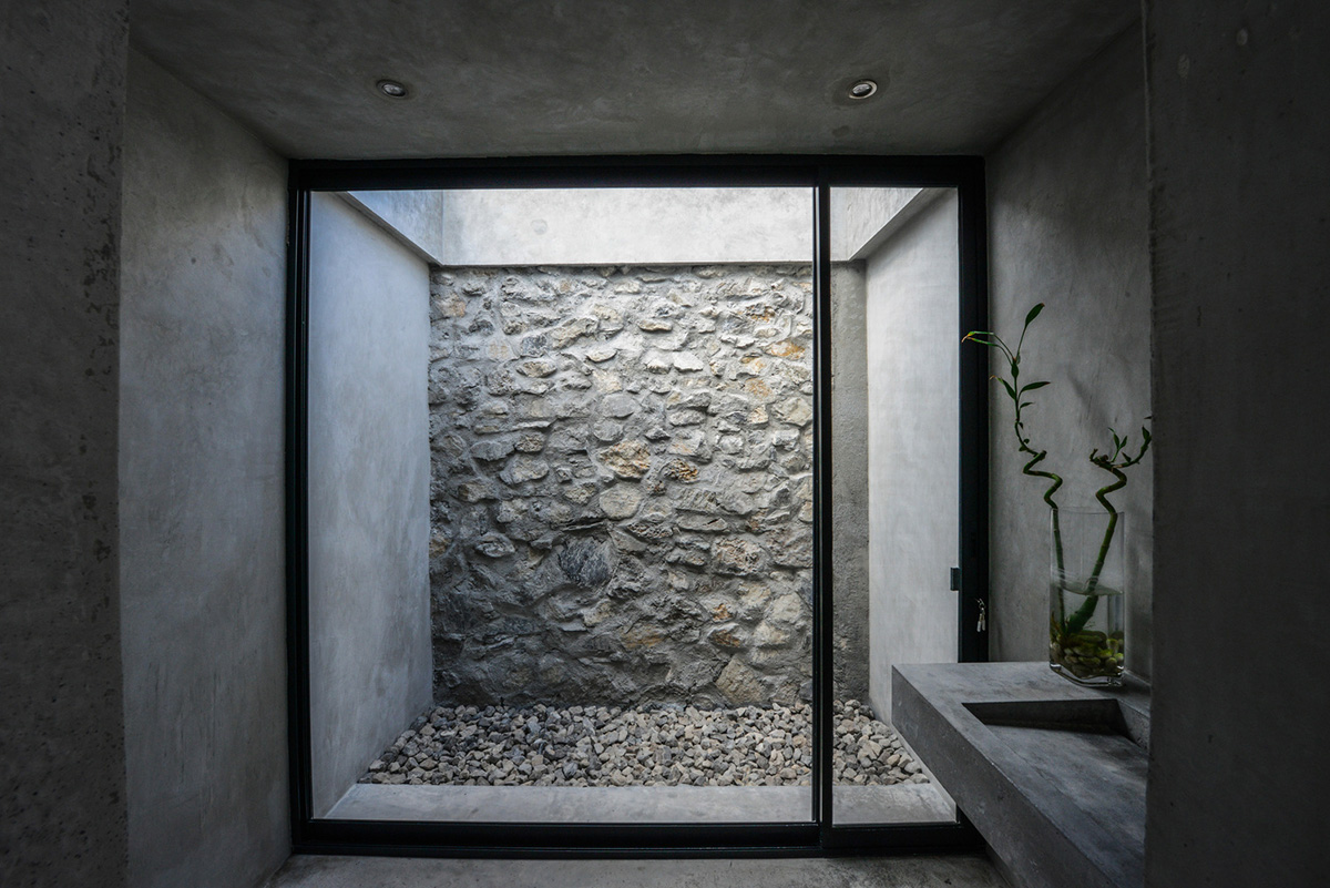 P+0 Arquitectura designs residence mixed with concrete and stone volumes on a complex terrain