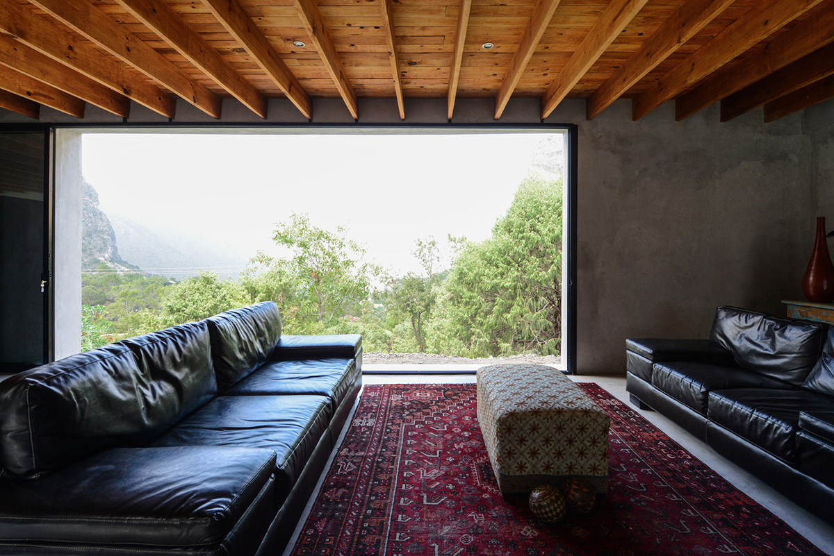 P+0 Arquitectura designs residence mixed with concrete and stone volumes on a complex terrain