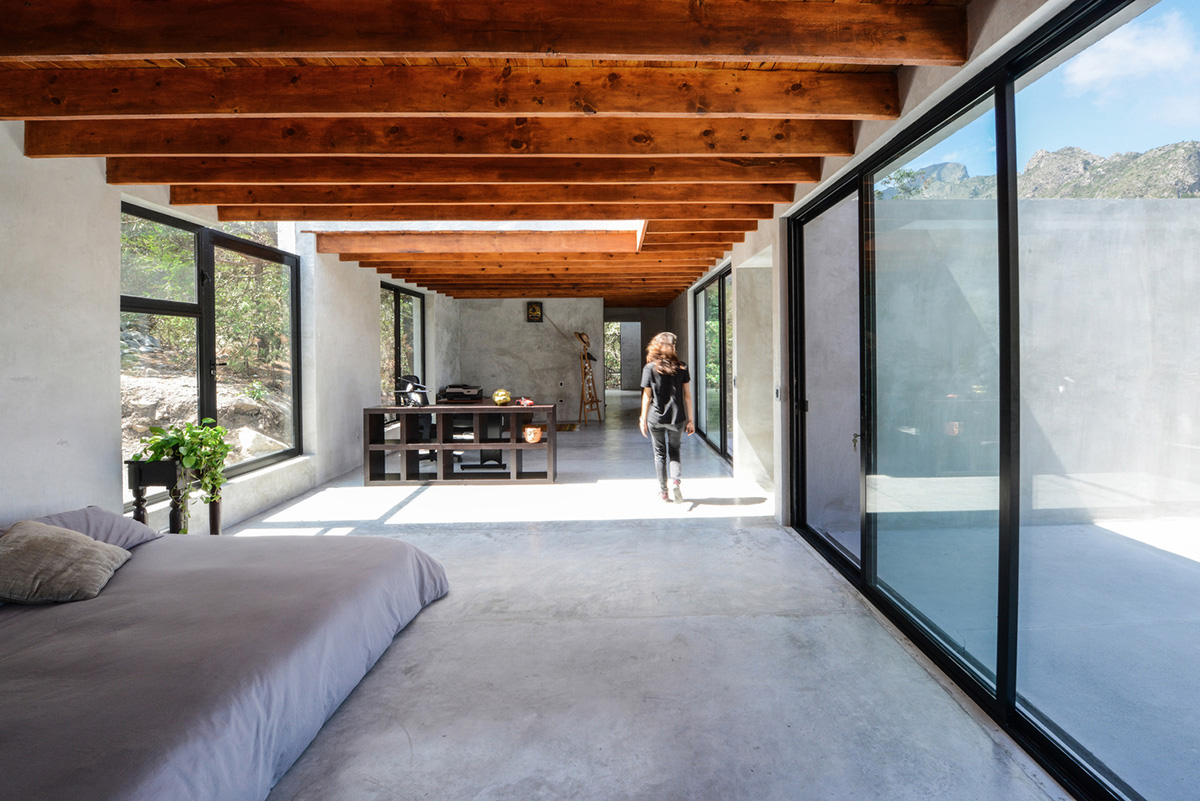 P+0 Arquitectura designs residence mixed with concrete and stone volumes on a complex terrain