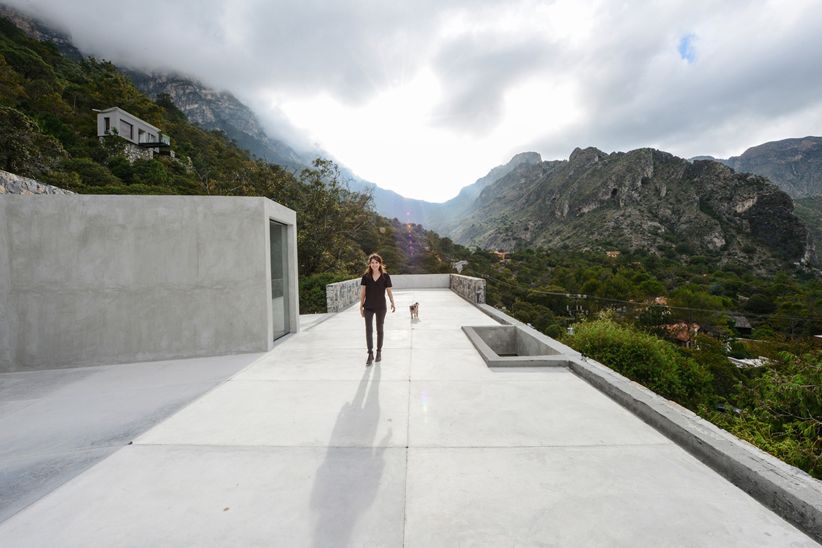 P+0 Arquitectura designs residence mixed with concrete and stone volumes on a complex terrain