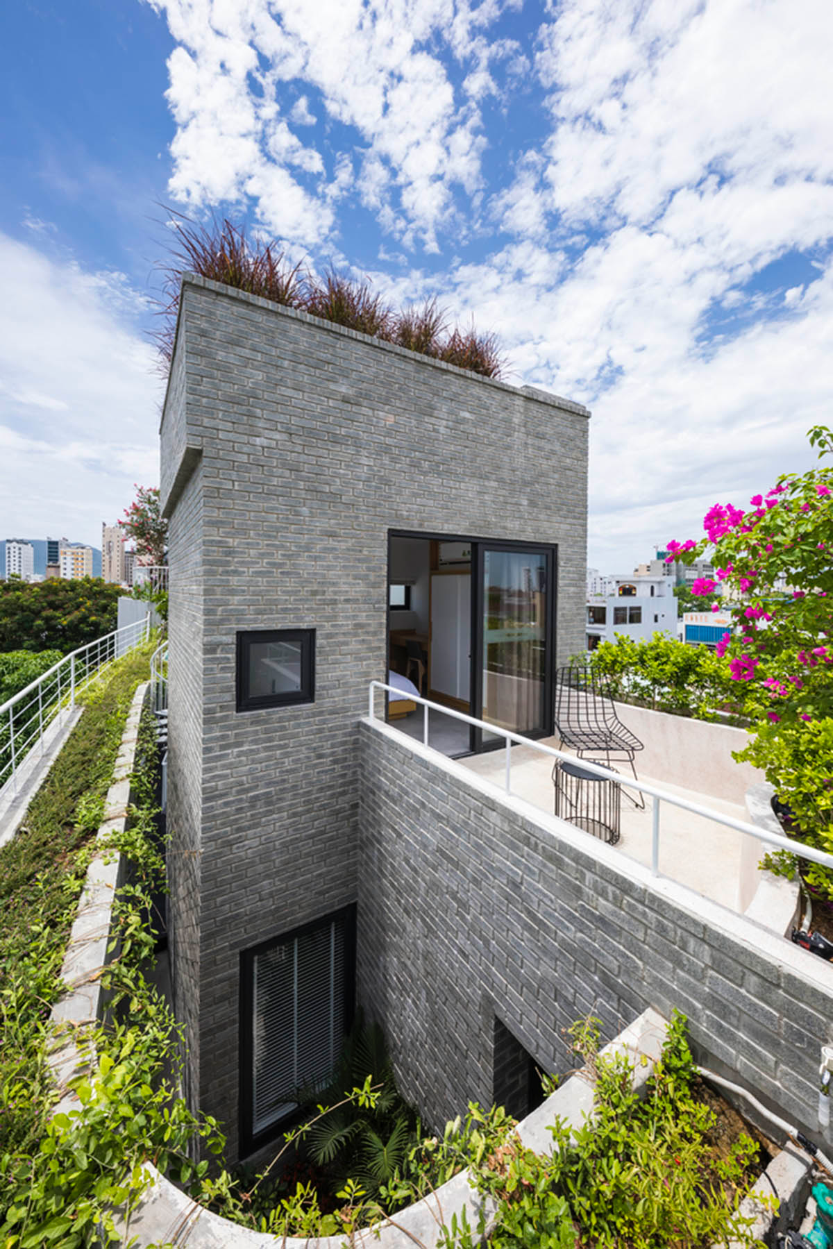 Ho Khue Architects brings jungle life into a terraced apartment building in the Da Nang City, Vietnam