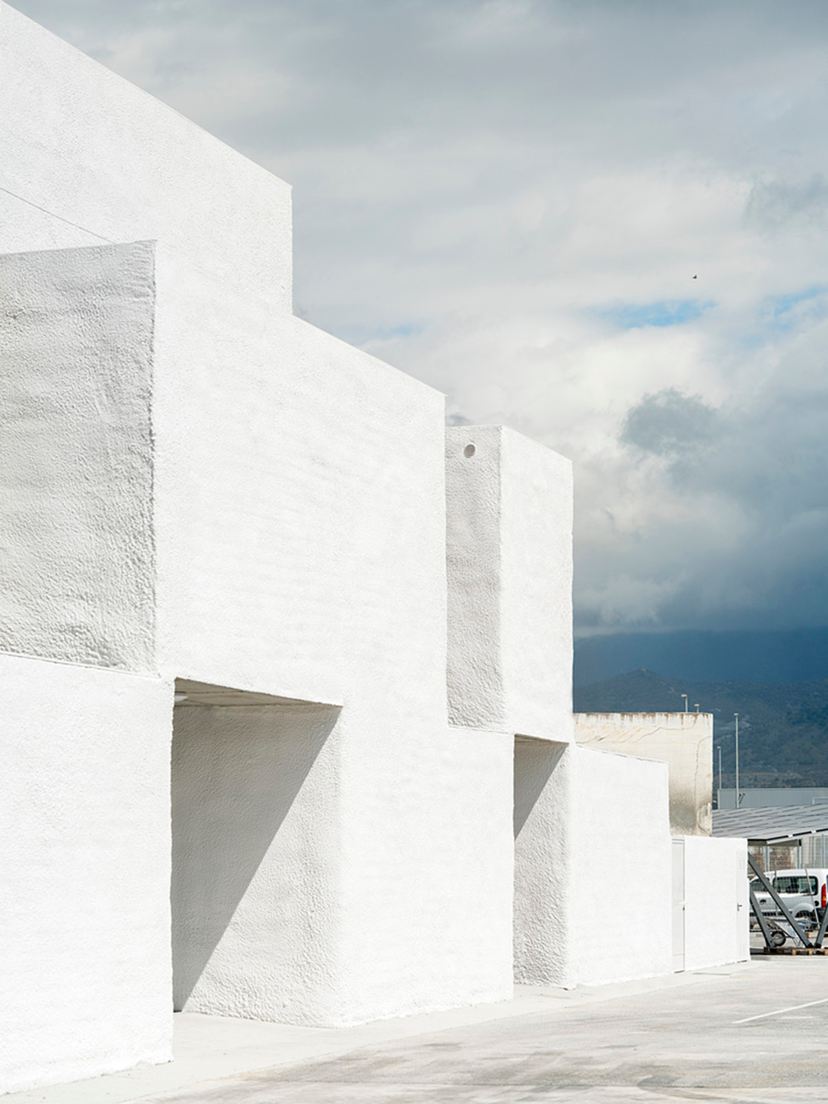 White cubic volumes combined with inward system of patios to create zero-energy Port Operations HQ
