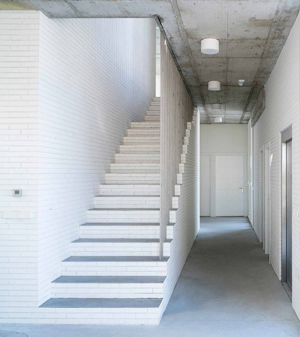 White cubic volumes combined with inward system of patios to create zero-energy Port Operations HQ