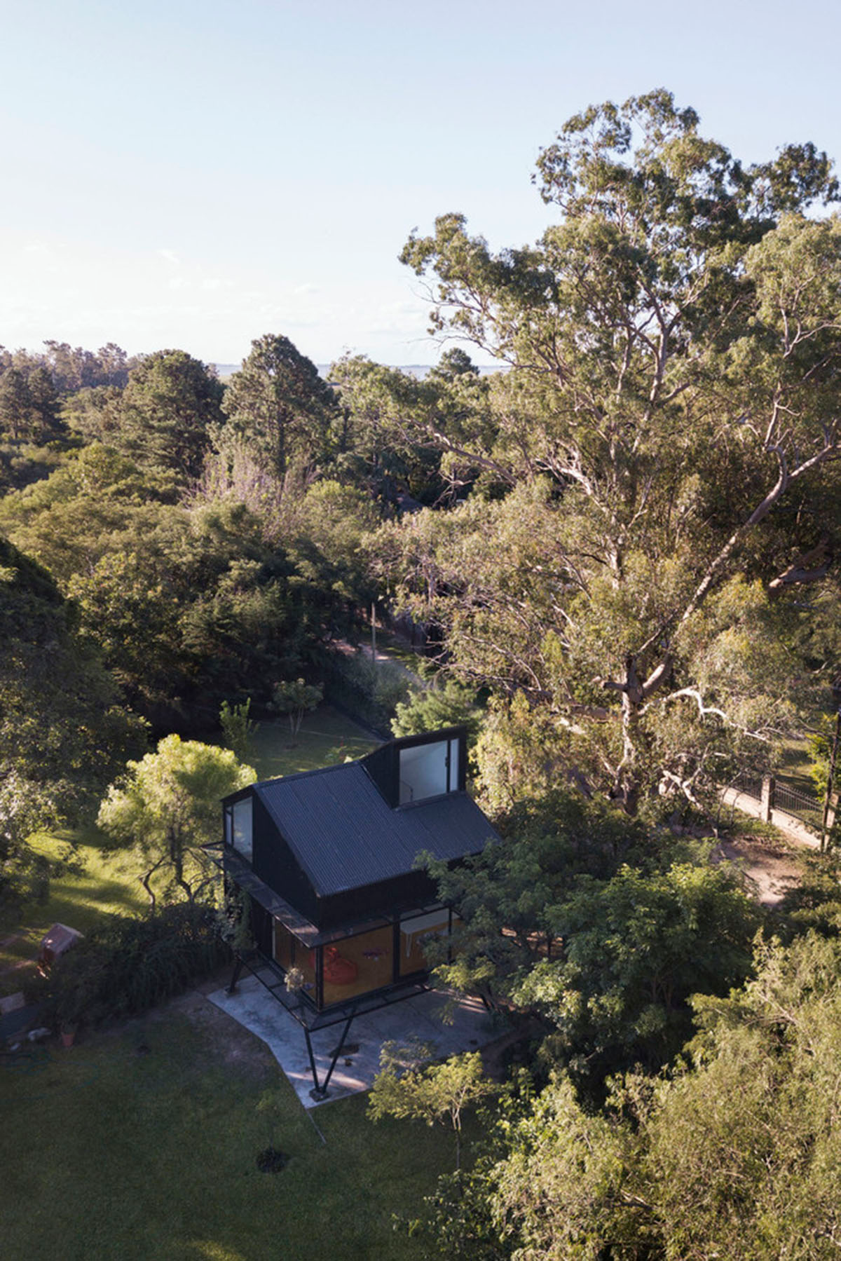This black metal tree house by Paschetta Cavallero Arquitectos disappears between the treetops